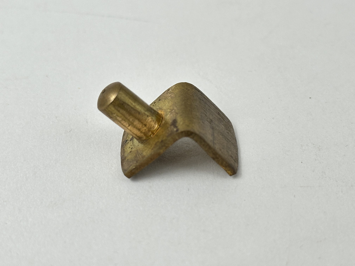 Bokskåp i mahogny med glasdörrar och låda nederst. Gavelformat överstycke med plats för fyra hörnkrön. Två krön har blomornament på två sidor, de andra två krönen har endast ornament på den ena sidan. Fem hyllplan, 20 platta hyllbärare i metall. Hålen för hyllbärarna klädda i mässing. Glasdörrarna med snidade dekorationer i form av bland annat cirklar och pilar. Dekorativa konsoler på bägge sidor dörrarna. Nyckelbrickor till dörrar och låda i ben.