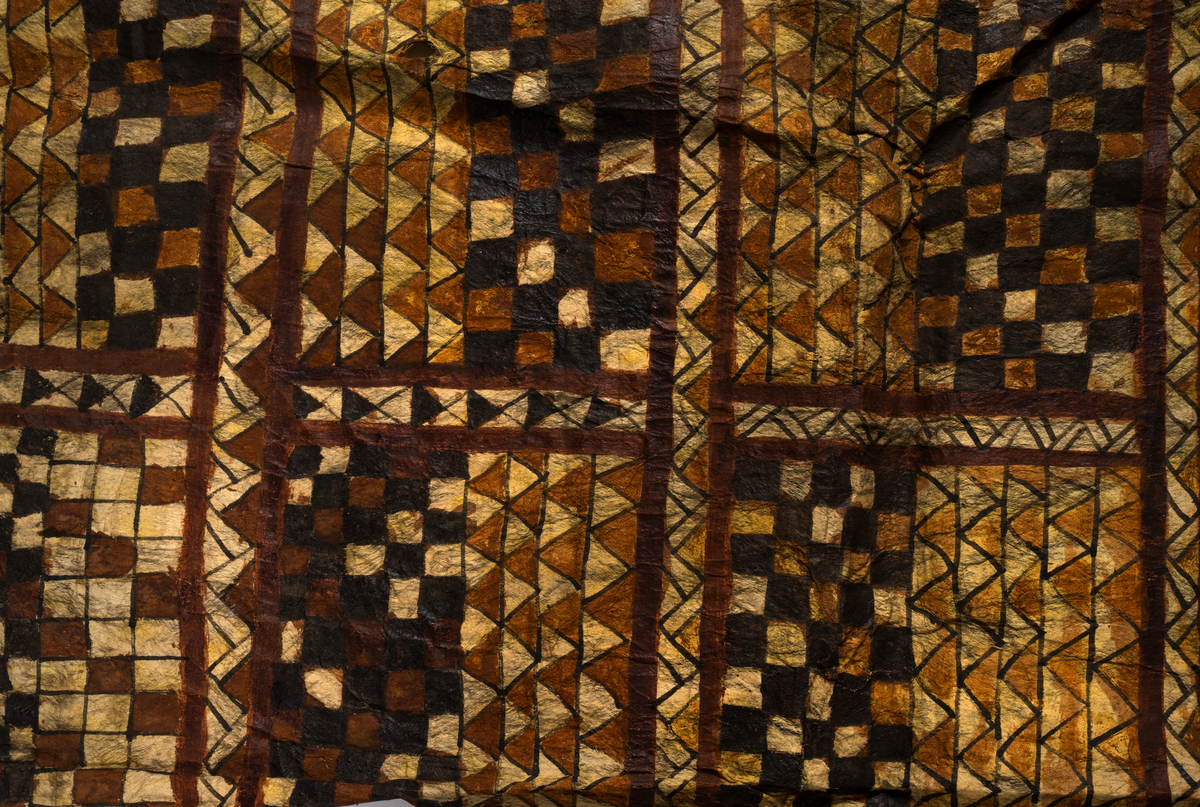 Tapa från Samoa.
Mönster i svartbrun färg indelad på längden i åtta fält med rutor och trianglar.