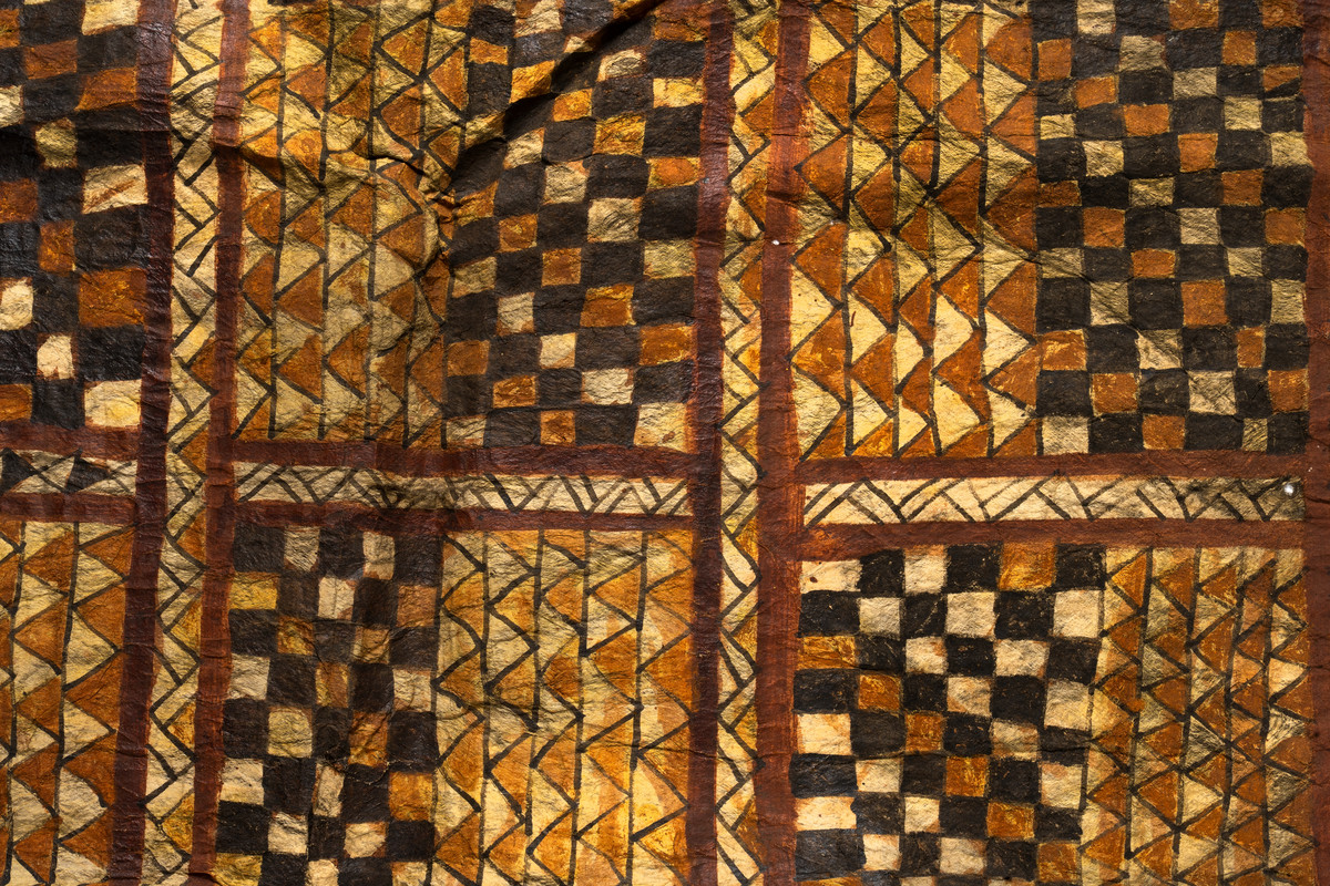 Tapa från Samoa.
Mönster i svartbrun färg indelad på längden i åtta fält med rutor och trianglar.