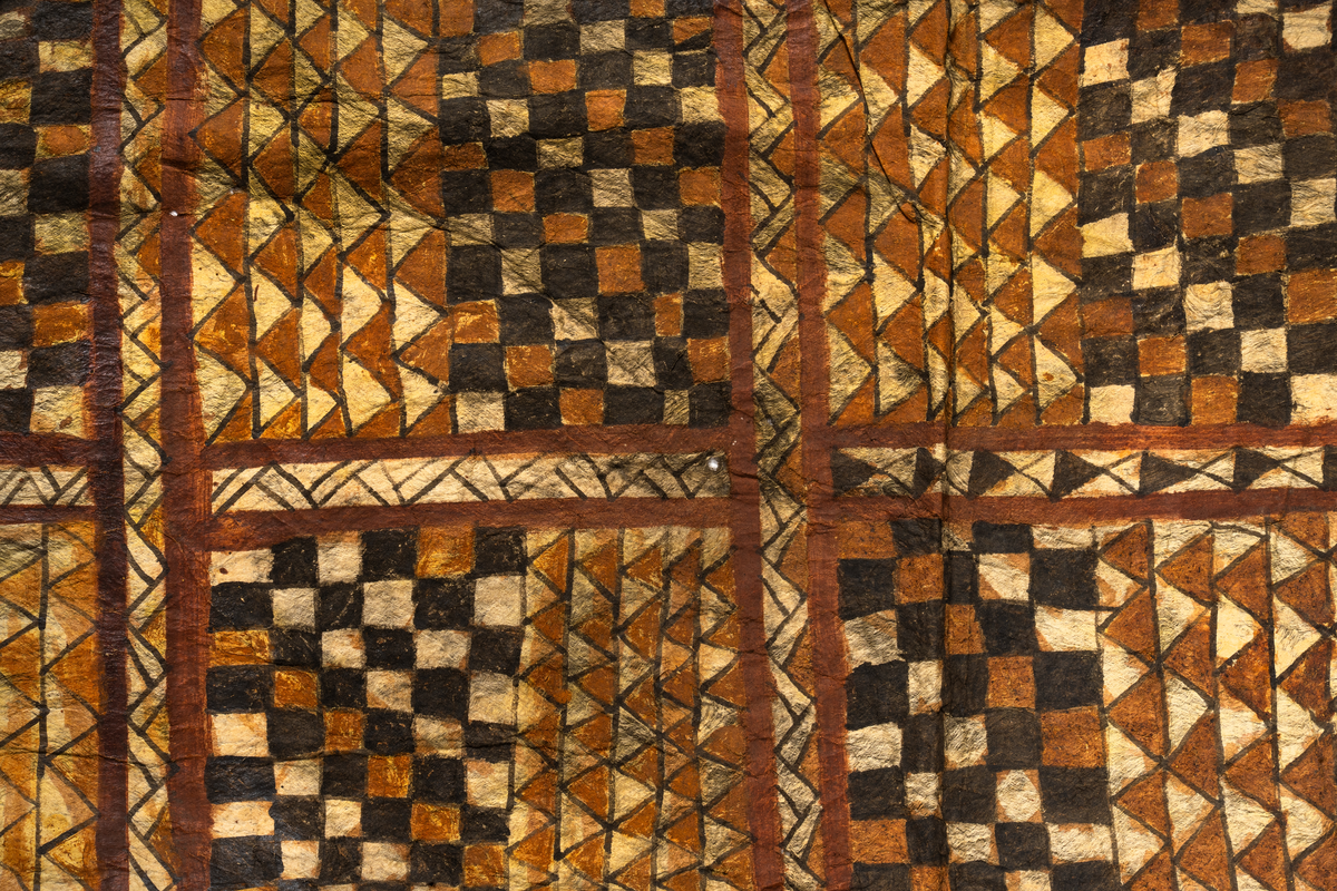 Tapa från Samoa.
Mönster i svartbrun färg indelad på längden i åtta fält med rutor och trianglar.