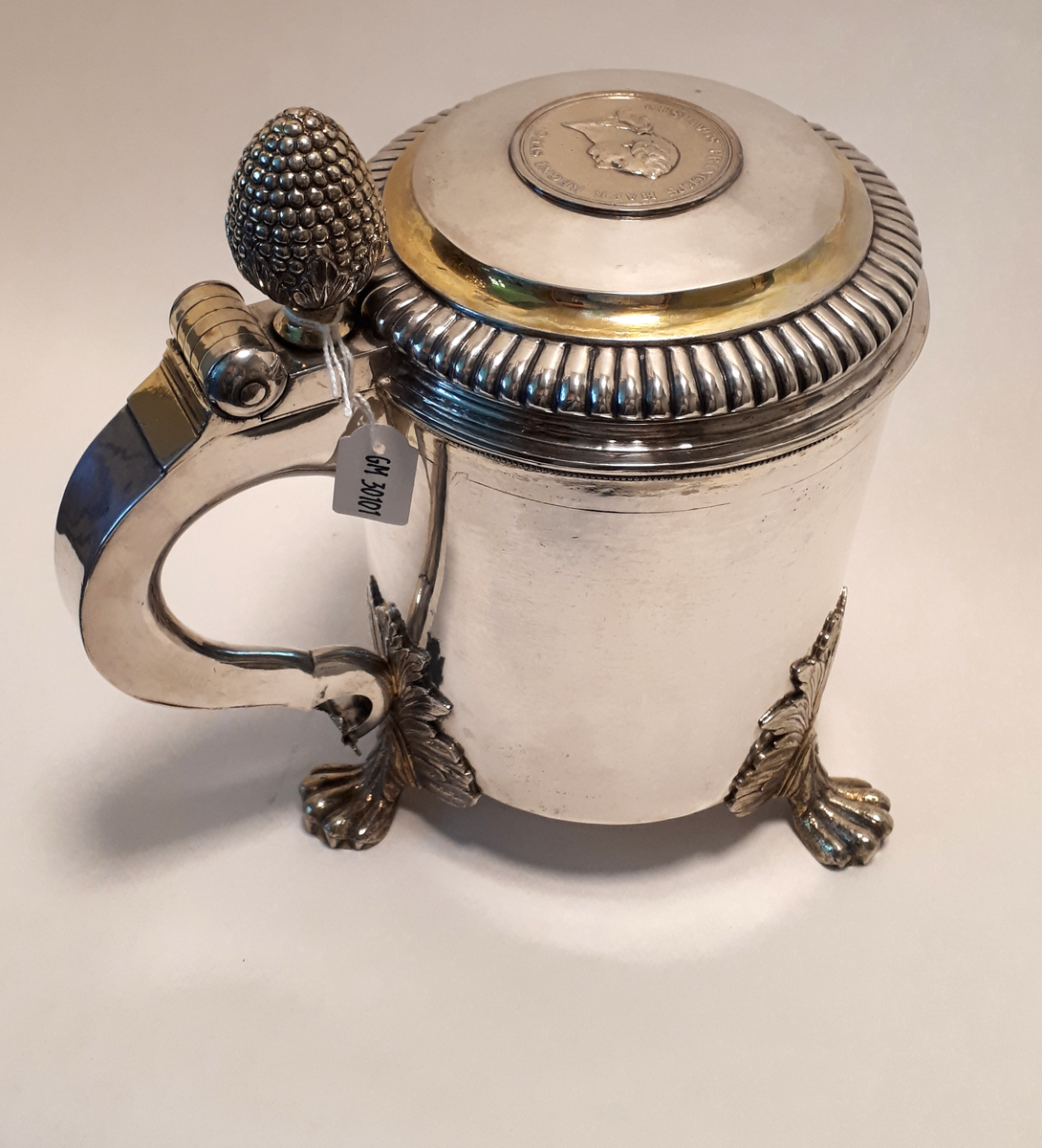 Dryckeskanna av silver. Anders Dunderberg, Gävle 1795. Cylindrisk på tre tassfötter med blad anfanger. Lock med godronnerad kant och infälld medalj, kronprins Gustav 1761. Hänkel med tumknopp i form av pinjekotte. Förgylld inuti samt på smärre partier på lock och hänkel.