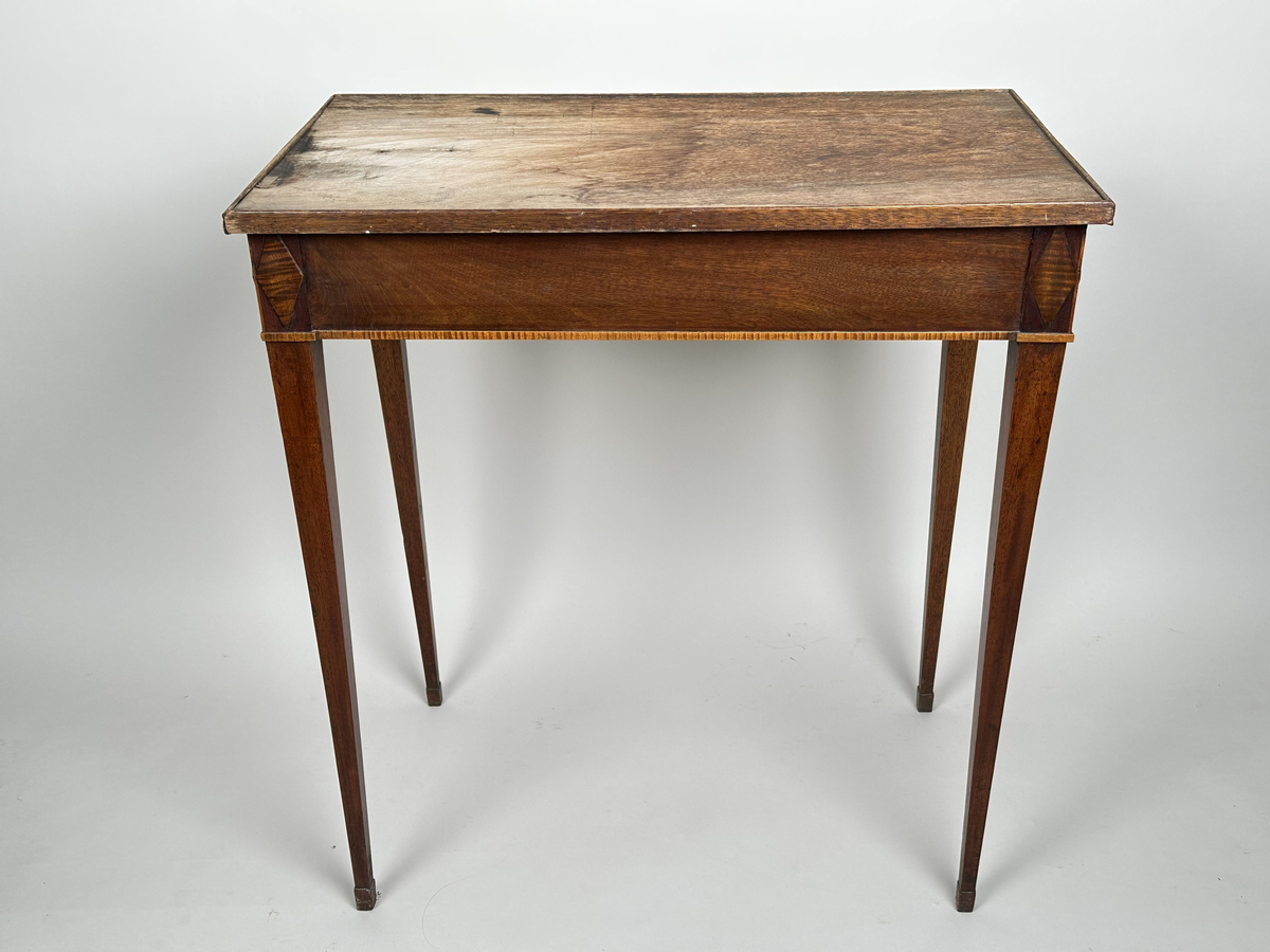 Bord, sengustavianskt. Furu med mahoganyfanér. Fyrkantiga, raka ben med avsmalning neråt och definierade avslut. Sarg med rombformad dekor i relief i samtliga hörn. I sargen låda med fackinredning. På lådans front infälld låskista med rund, dekorativ nyckelskylt i trä. Blad i slitet och fuktskadat skick.