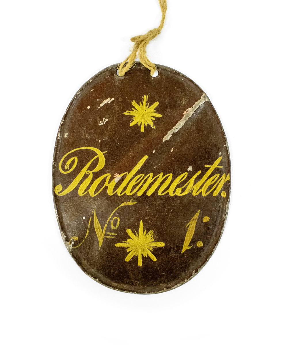 Ulike skilt av metall, antagelig for Brannmannskap. Alle skiltene har håndmalt skrift og dekor.

Består av 6 små ovale skilter:
1. Vagt, Rode No2, L No45
2. Vagt, Rode No2, L No46
3. Vagt, Rode No2, L No46
4. Vagt, Rode No?, L No?
5. Seil No5., L nO4
6. ?

Og to litt større ovale skilter:
7. Adjutant
8. Rodemester

Og to halvmåneformede skilter:
9. Leutnant No2
10. Leutnant No2
