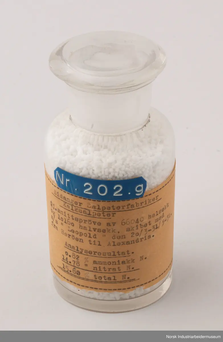 Åtte sylindriske laboratorieflasker i glass som inneholder kalksalpeter-prøver fra 1929, 1931 og 1932.
1. Gjennomsnittsprøve ferdigvare 23/6 - 29/6 . 1929
2. Gjennomsnittsprøve ferdigvare 14/7 - 20/7 . 1929
3. Gjennomsnittsprøve ferdigvare 21/7 - 27/7 . 1929
4. Salpeterprøve sendt til Tyskland 27/7. 1929
5. Gjennomsnittsprøve ferdigvare 26/7 - 2/8 . 1929
6. Gjennomsnittsprøve ferdigvare 18/8 - 24/8 . 1929
7. Gjennomsnittsprøve ferdigvare 20/3 - 31/3 . 1931
8. Gjennomsnittsprøve ferdigvare 18/1 - 25/1 . 1932