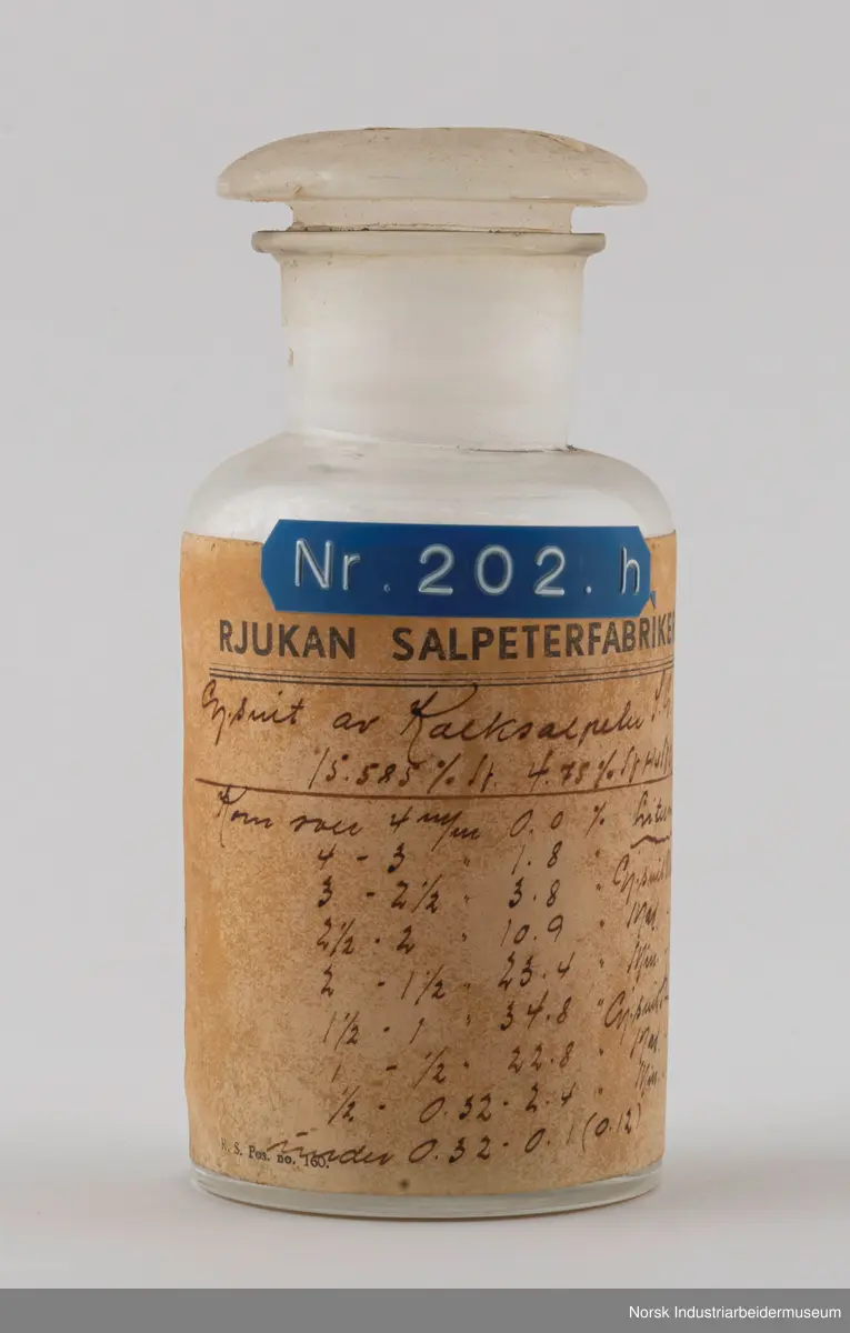 Åtte sylindriske laboratorieflasker i glass som inneholder kalksalpeter-prøver fra 1929, 1931 og 1932.
1. Gjennomsnittsprøve ferdigvare 23/6 - 29/6 . 1929
2. Gjennomsnittsprøve ferdigvare 14/7 - 20/7 . 1929
3. Gjennomsnittsprøve ferdigvare 21/7 - 27/7 . 1929
4. Salpeterprøve sendt til Tyskland 27/7. 1929
5. Gjennomsnittsprøve ferdigvare 26/7 - 2/8 . 1929
6. Gjennomsnittsprøve ferdigvare 18/8 - 24/8 . 1929
7. Gjennomsnittsprøve ferdigvare 20/3 - 31/3 . 1931
8. Gjennomsnittsprøve ferdigvare 18/1 - 25/1 . 1932
