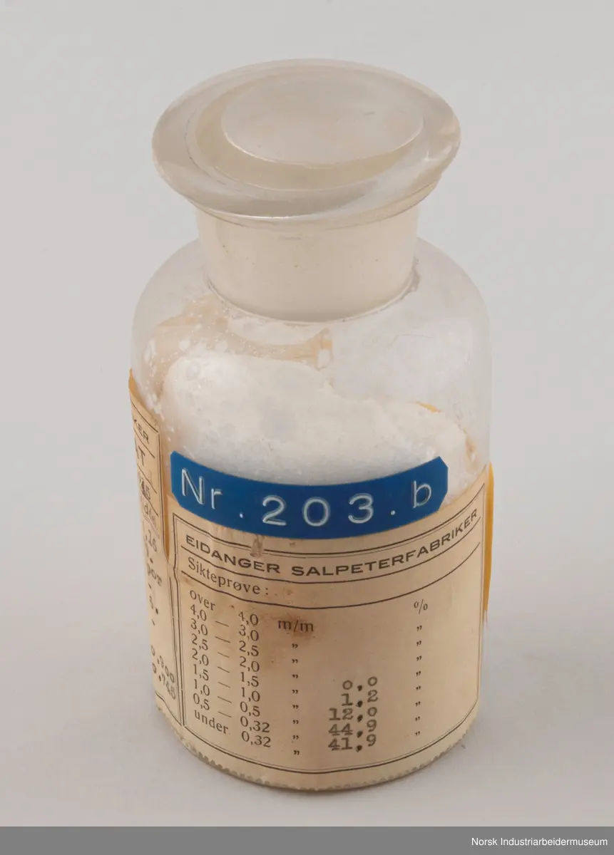 Sylindrisk laboratorieflaske som inneholder ukeprøve av ammoniumnitrat fra 4-11/11 1945.