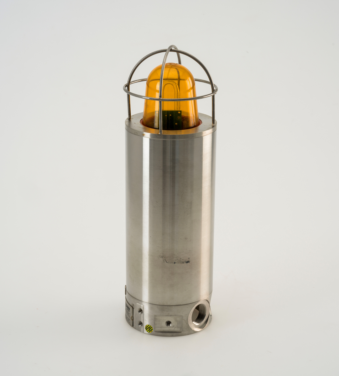 Sylinderformet signallampe av rustfritt stål med kuppel av plast. Lampen er ubrukt.