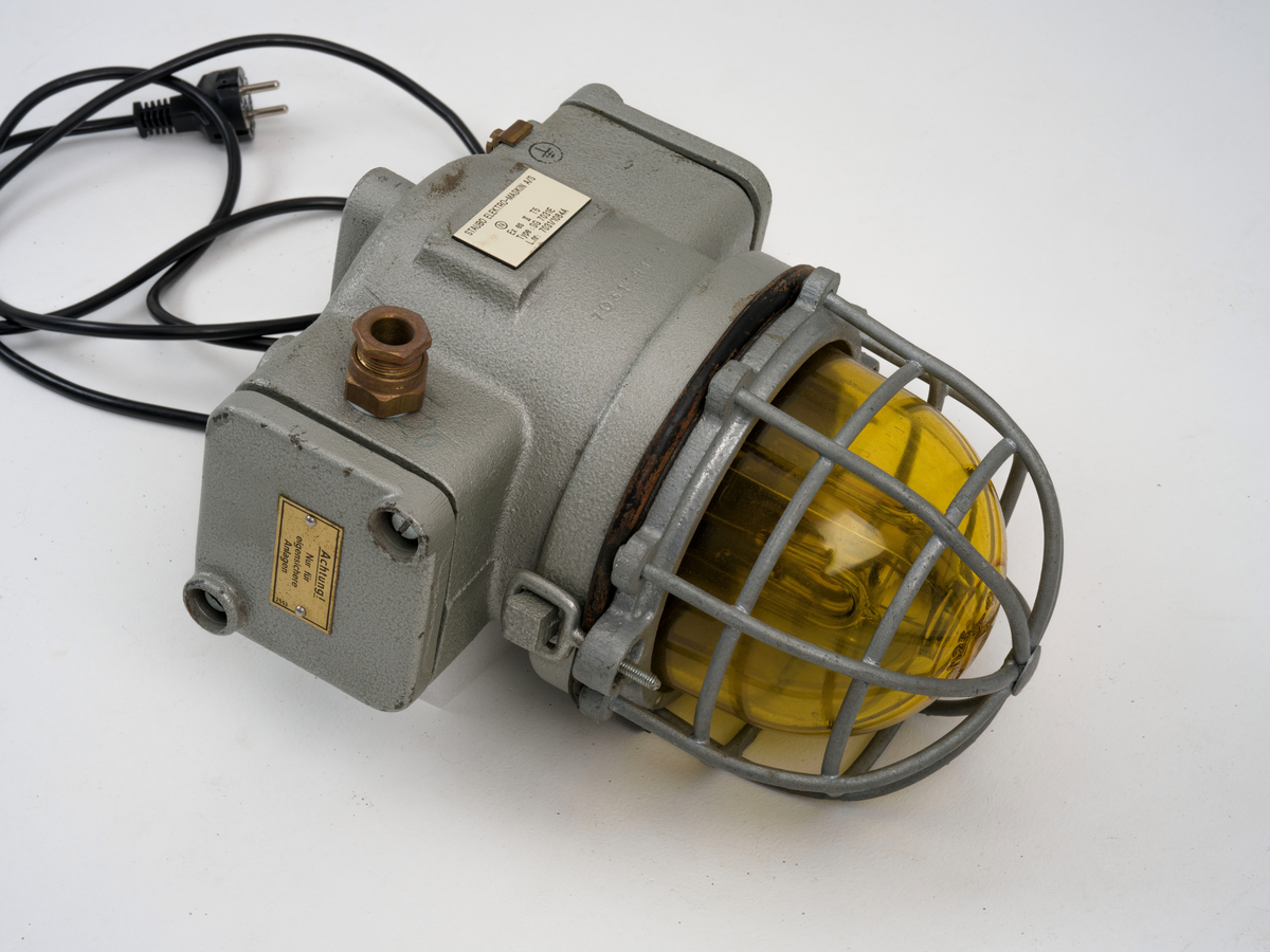 Signallampe med kuppel av glass og to avtagbare deksler som er festet med skruer.