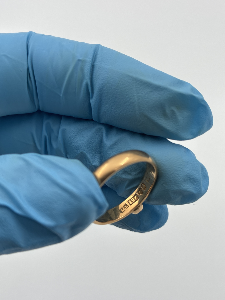 Guldring med granat.

Stämplar: 
Mästarstämpel: LEL = Ludvig Edvard Liljeblad
20K = 20 karat
Kattfot
Ortsstämpel: A = Alingsås
Årsbokstav X5 = 1876