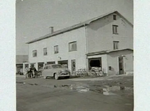 Tofta Handelsförening, butik 5, i Kärradal. Artikel i samband med bilden publicerad i Varbergs Tidning 1958-04-05. En bil och cyklar är parkerade utanför affären.