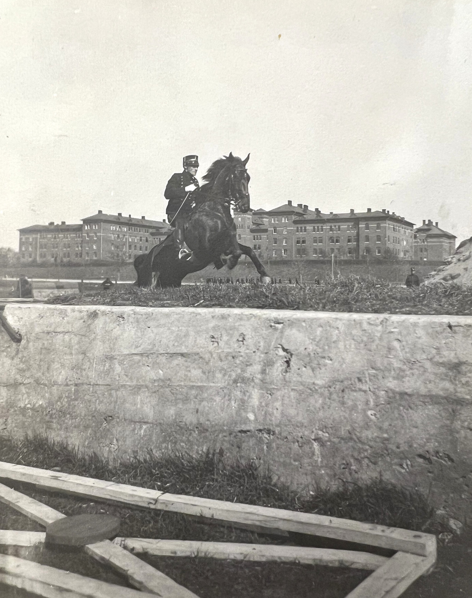Smålands artilleriregemente, A 6. Löjtnant G R Zandrén på hästen "Ultra". Kasernen i bakgrunden. Foto från c:a år 1915.