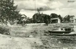 Gårdar intill en strandkant i Bollnäsområdet. Några båtar li