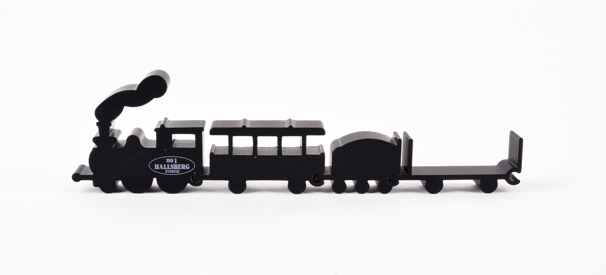 Pusseltåg?
Leksakståg ?  i svartmålat metall. Bestående av fyra delar: ett ånglok, en personvagn och två godsvagnar. Text på loket "no 1 HALLSBERG SVERIGE".