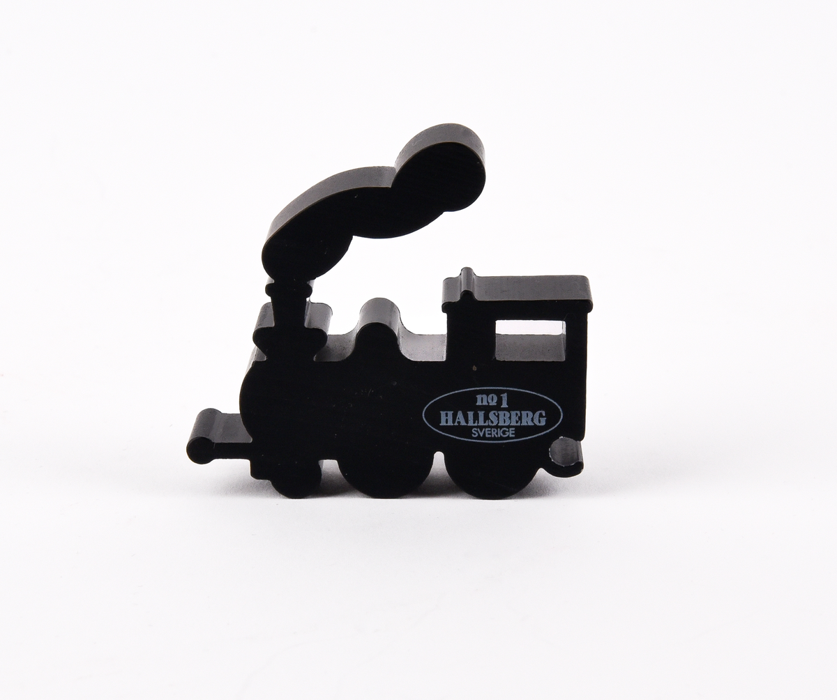 Pusseltåg?
Leksakståg ?  i svartmålat metall. Bestående av fyra delar: ett ånglok, en personvagn och två godsvagnar. Text på loket "no 1 HALLSBERG SVERIGE".