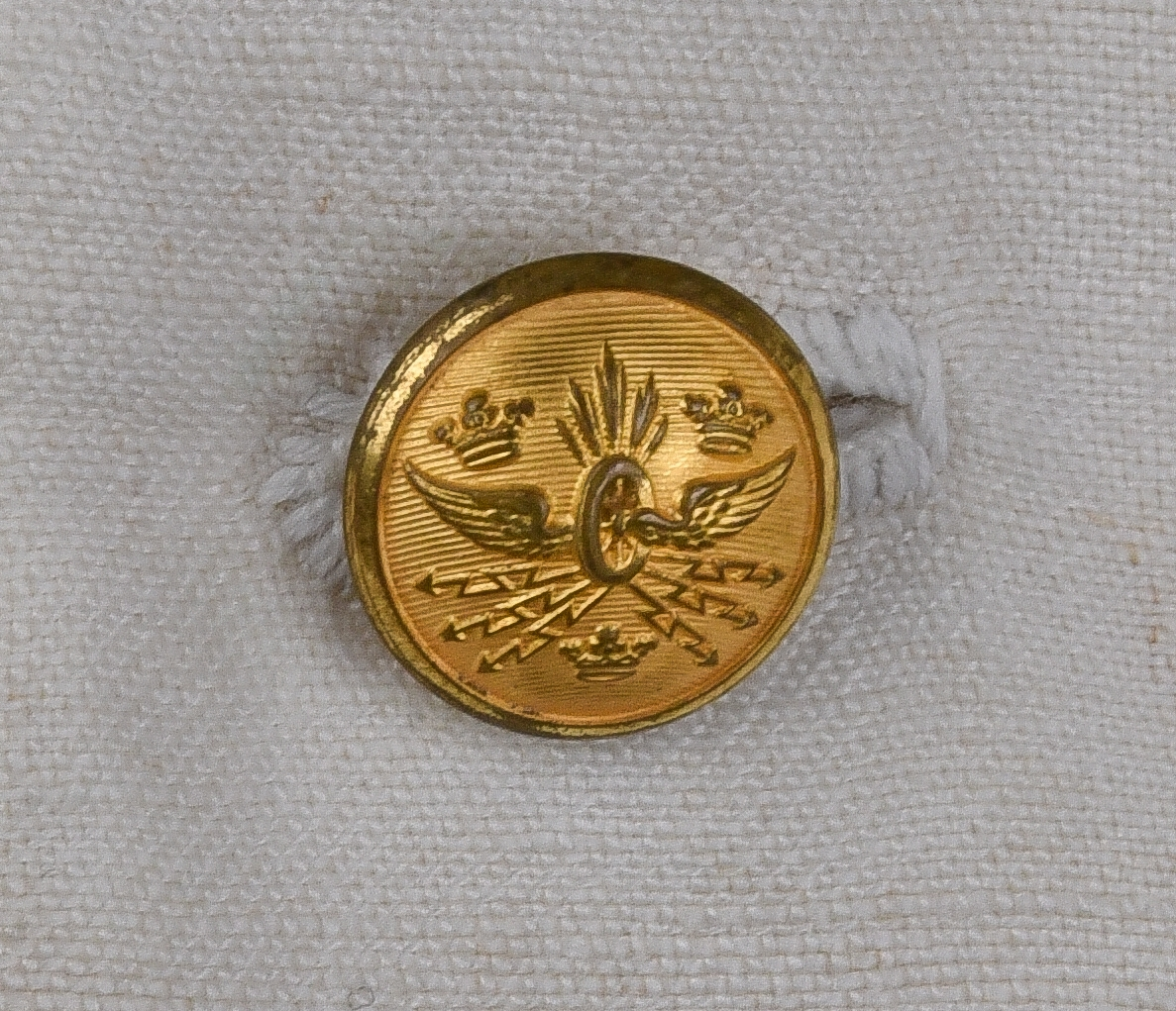 Kavaj av vitt linnetyg, dubbelknäppt med åtta knappar i brännförgylld gulmetall. Knappar enligt 1897-års reglemente. Framtill en snedställd bröstficka på vänster sida och två sidofickor. Löstagbara axelklaffar med gradbeteckning från år 1955 för bl.a. stationsmästare med tillhörande knappar från år 1953. Axelvaddar på insidan kavajen. Vid nacken hank för upphängning av kavajen. Rosa lapp från kemtvätt med text "GÄVLETVÄTTEN 1774 6/2" häftad vid hanken.
Kavajen tillhör 1921-års bestämmelser.