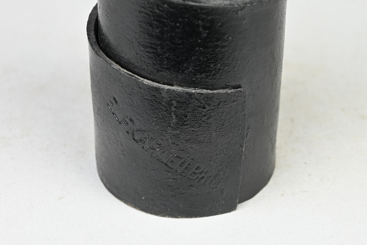 Prov på buffertfjäder, svart. Från Elfkarleö bruk. Tillhörande lapp med samma notering. Märkning på provet med påklistrad etikett med notering: "225". Märkning på provet med notering: "Elfkarleöbruk".