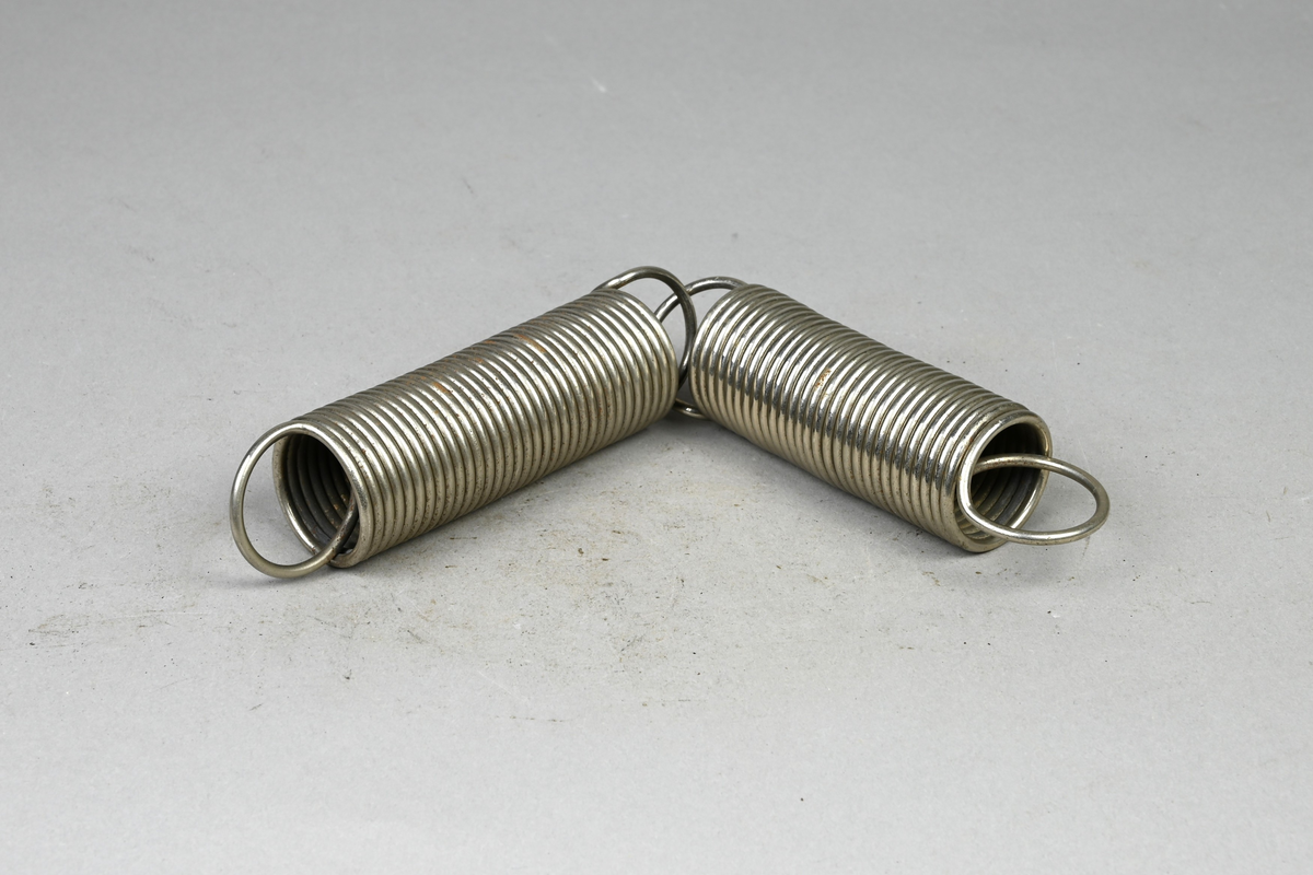 Två prover på blankförnicklad spiralfjäder av stål. Tillverkade av A-B. Spiralfabriken. Tillhörande lapp med samma notering. Tillhörande etikett med notering: "313. Blankförnicklad stålfjäder med lika hård lindning af samma trådsort."