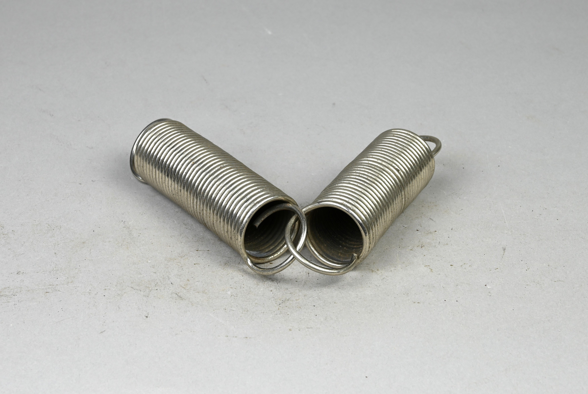 Två prover på blankförnicklad spiralfjäder av stål. Tillverkade av A-B. Spiralfabriken. Tillhörande lapp med samma notering. Tillhörande etikett med notering: "313. Blankförnicklad stålfjäder med lika hård lindning af samma trådsort."