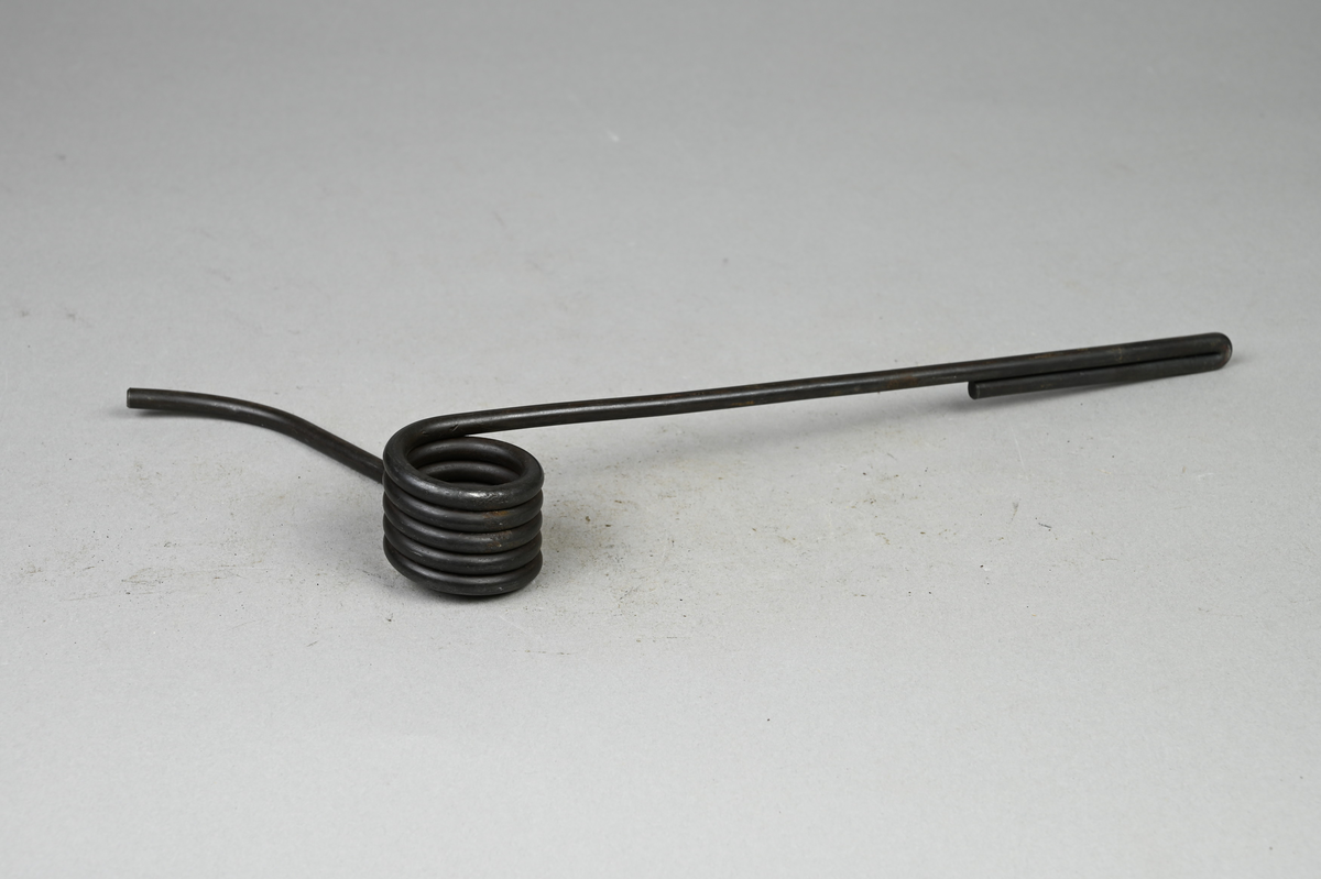 Prov på dörrstängarespiralfjäder, svart. Tillhörande lapp med samma notering.