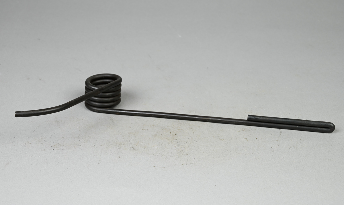 Prov på dörrstängarespiralfjäder, svart. Tillhörande lapp med samma notering.