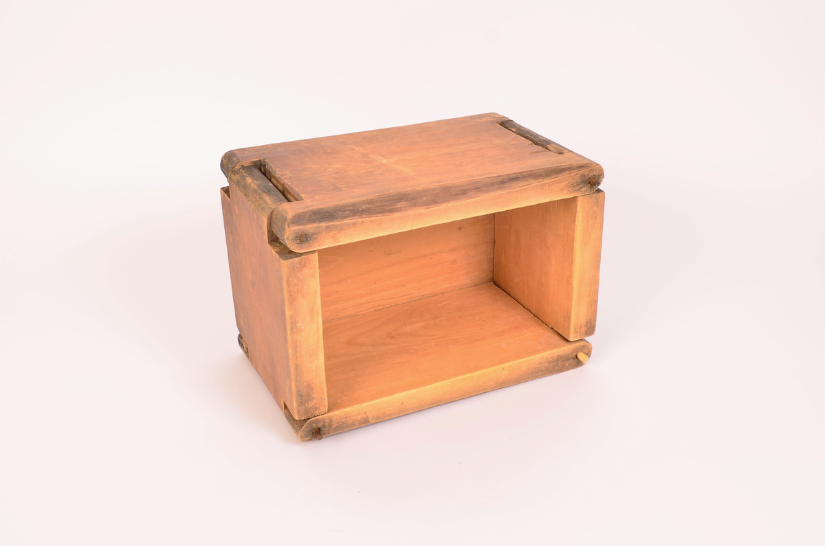 Tre, ingen dekorasjoner. Bunnen er satt inn i veggene ved not/fjær-systemet. veggene satt i hverandre, i tre hjørner er det satt i stikker av jern, i det fjerde, som er åpning er det satt i ei trestikke, ser nokså ny ut.