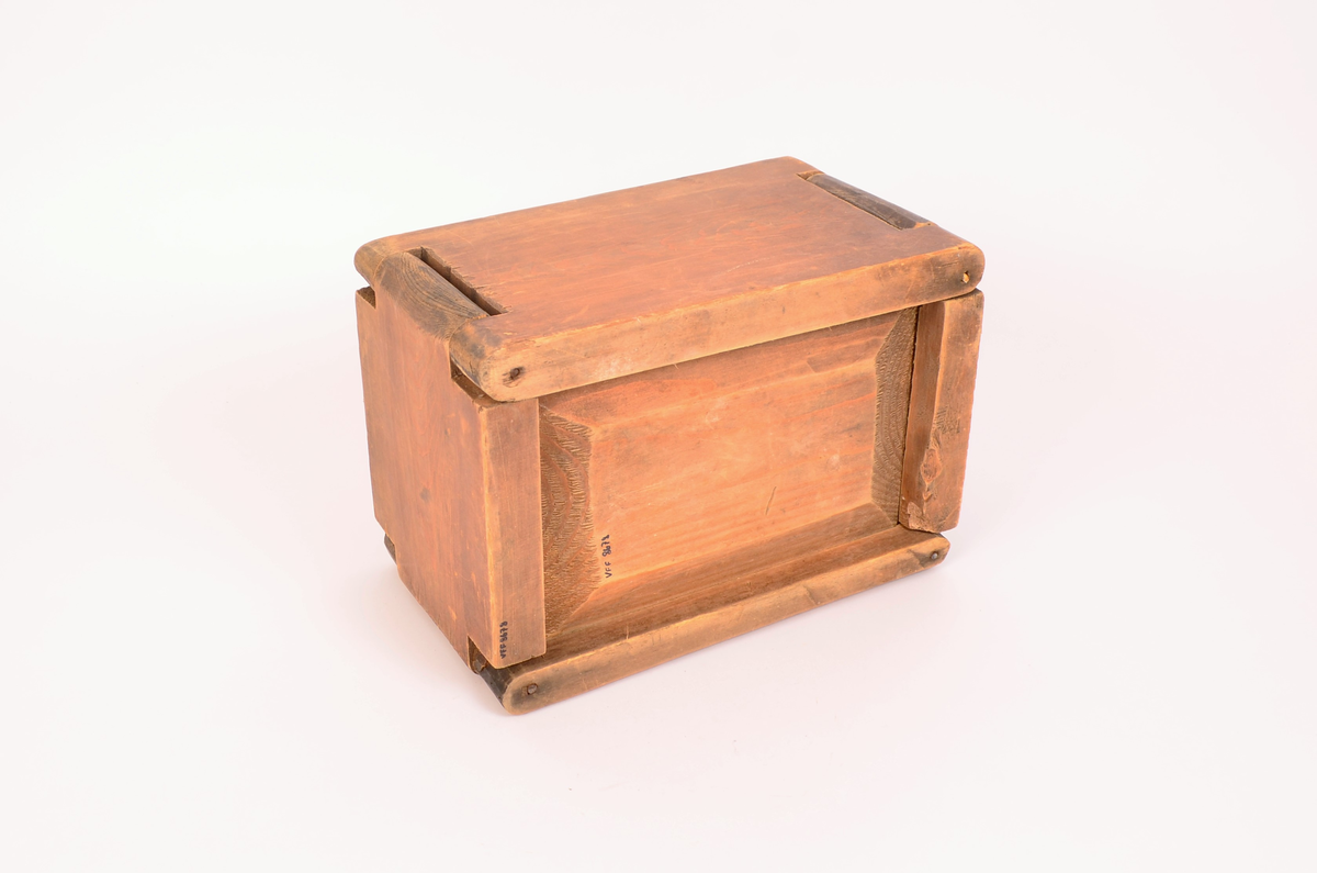 Tre, ingen dekorasjoner. Bunnen er satt inn i veggene ved not/fjær-systemet. veggene satt i hverandre, i tre hjørner er det satt i stikker av jern, i det fjerde, som er åpning er det satt i ei trestikke, ser nokså ny ut.