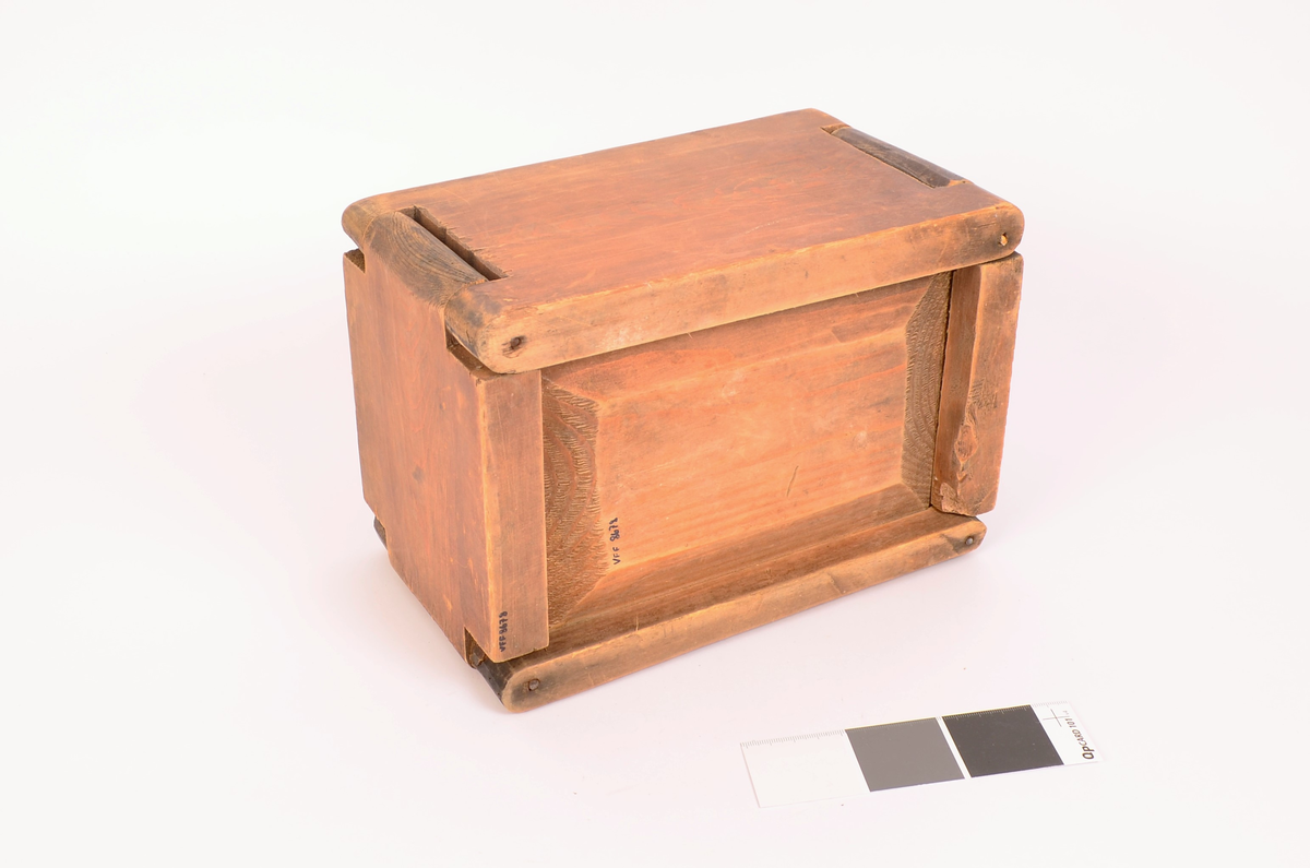 Tre, ingen dekorasjoner. Bunnen er satt inn i veggene ved not/fjær-systemet. veggene satt i hverandre, i tre hjørner er det satt i stikker av jern, i det fjerde, som er åpning er det satt i ei trestikke, ser nokså ny ut.