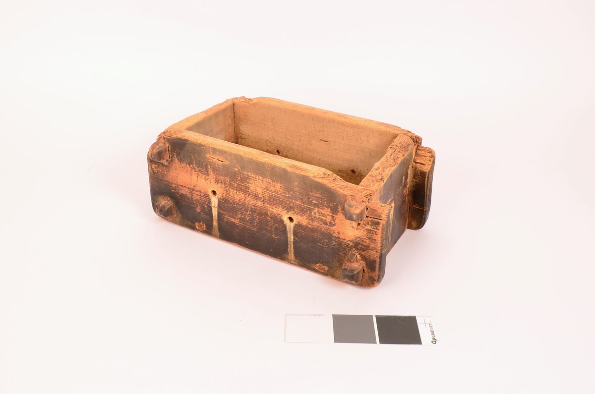 rektangulær kasseformat. Forma er av tre. Hull i botn og i sider. Veggene satt i hverandre ved hjelp av sine trepinner en oppe og en nede i hvert hjørne. forma er svært nedslitt på kantene. Totrepinner i satt på tvers under, før å holde botnen.