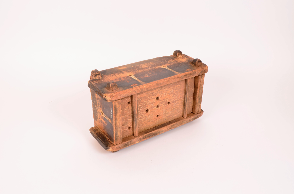 rektangulær kasseformat. Forma er av tre. Hull i botn og i sider. Veggene satt i hverandre ved hjelp av sine trepinner en oppe og en nede i hvert hjørne. forma er svært nedslitt på kantene. Totrepinner i satt på tvers under, før å holde botnen.