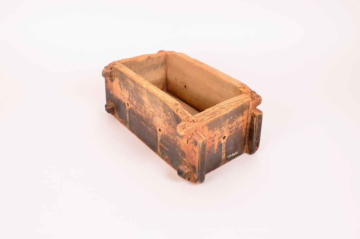 rektangulær kasseformat. Forma er av tre. Hull i botn og i sider. Veggene satt i hverandre ved hjelp av sine trepinner en oppe og en nede i hvert hjørne. forma er svært nedslitt på kantene. Totrepinner i satt på tvers under, før å holde botnen.