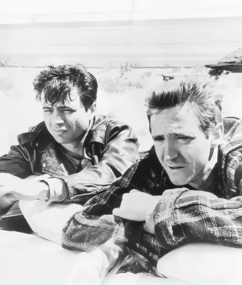 Två män med ett ökenlandskap i bakgrunden.