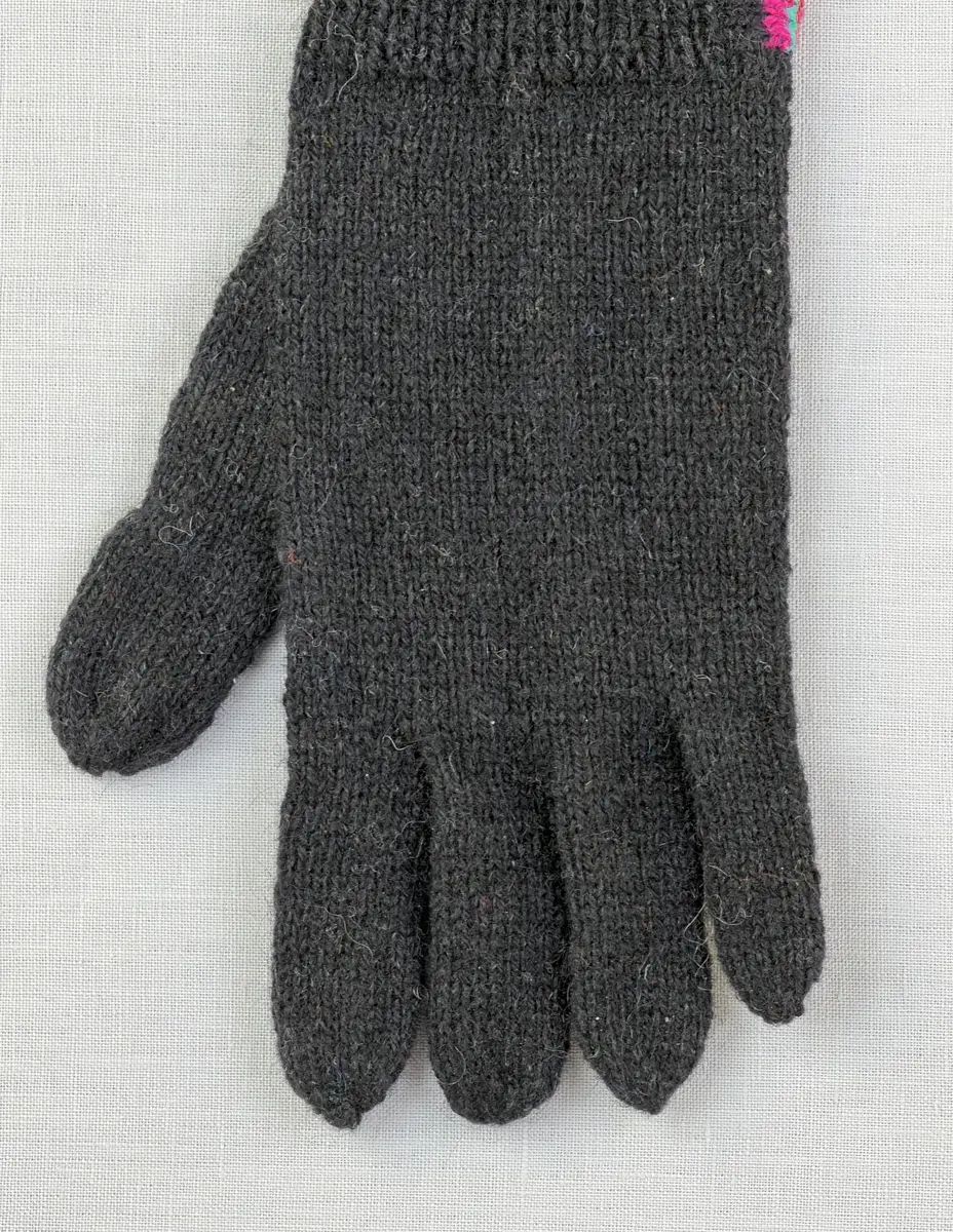 En stickad fingervante, med mudd/krage i 1-1 resår (1 rät och 1 avig maska) och delstickad kil i slätstickning samt vante i slätstickning, av 2-trådigt ullgarn. Vanten har stickad kiltumme och fingrarna har strålhoptagning i toppen.
