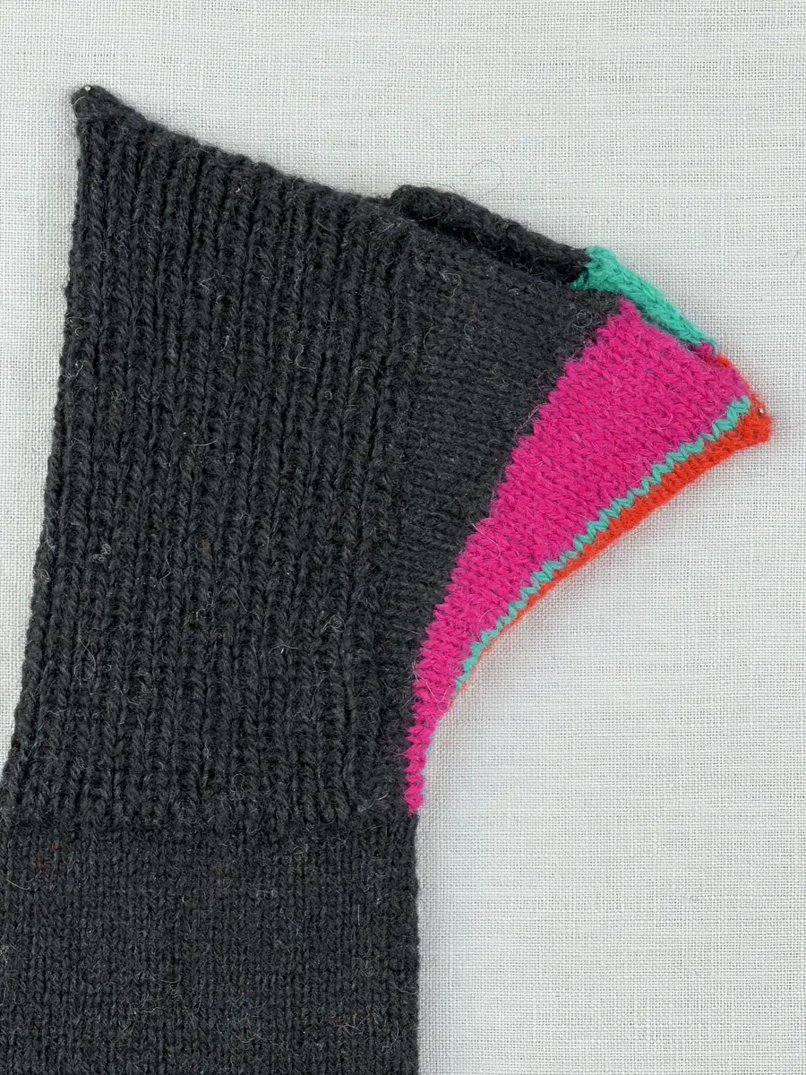 En stickad tumvante, med mudd/krage i 1-1 resår (1 rät och 1 avig maska) och delstickad kil i slätstickning samt vante i slätstickning, av 2-trådigt ullgarn. Vanten har stickad kiltumme och bandhoptagning i toppen.
