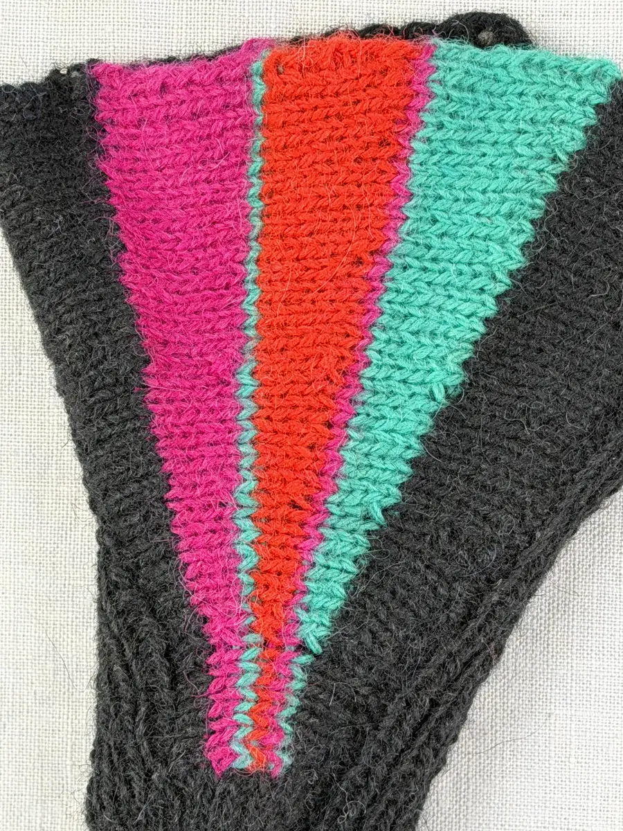 En stickad tumvante, med mudd/krage i 1-1 resår (1 rät och 1 avig maska) och delstickad kil i slätstickning samt vante i slätstickning, av 2-trådigt ullgarn. Vanten har stickad kiltumme och bandhoptagning i toppen.
