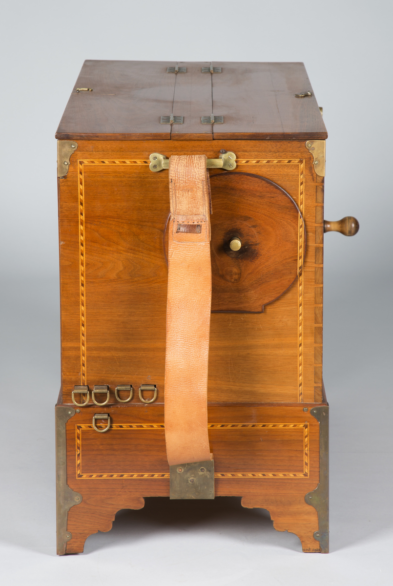 Lirekasse "Storspælle" med tilhørende rull (B). Instrumentet har 28 toner, fem register og todelt belg. Kassen er dekorert med intarsia.

Toner: C, D, F, G, A, H, c, d, e, f, f#, g, a, b, h, c’, d’, e’, f’, f#’, g’, a’, b’, h’, c’’, d’’, e’’, f’’
[men fremre reg står C, C#, D, E, F, G, .. uklar betydning]

Register:
8’ gedakt (plassert under bunn, unntatt C-pipen, som ligger over de andre stående pipene)
4’ 8 åpne piper i diskant, resten gedakt
2 2/3’ «kvint»; 13 åpne piper
2’ kun melodi (f# og oppover), totalt 17 åpne piper
1 3/5 «ters» NB! 2’ i bassregister (f og nedover)

Todelt belg. Spesiell dekor på utlassventilsstang.
Forslag laget av bjørk («uvanlig for å være Tharaldsen» brukte annet løvtre vanligvis» JMF)
«Pen intarsia på kasse, god for å vøre Tharaldsen»JMF
Pipene er relativt rike på overtoner, sanns et resultat av en relativt lav oppsnitt (JMF).