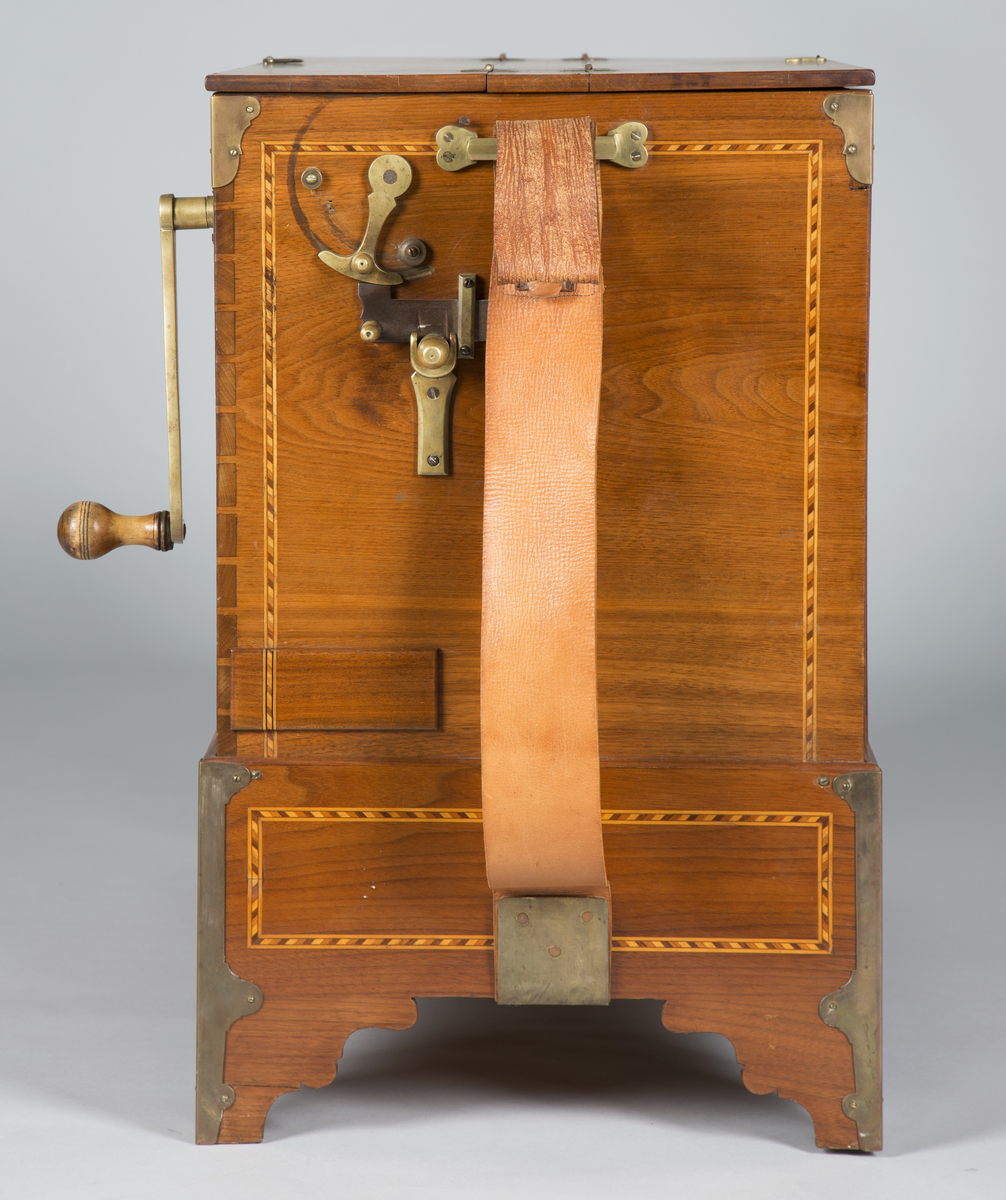 Lirekasse "Storspælle" med tilhørende rull (B). Instrumentet har 28 toner, fem register og todelt belg. Kassen er dekorert med intarsia.

Toner: C, D, F, G, A, H, c, d, e, f, f#, g, a, b, h, c’, d’, e’, f’, f#’, g’, a’, b’, h’, c’’, d’’, e’’, f’’
[men fremre reg står C, C#, D, E, F, G, .. uklar betydning]

Register:
8’ gedakt (plassert under bunn, unntatt C-pipen, som ligger over de andre stående pipene)
4’ 8 åpne piper i diskant, resten gedakt
2 2/3’ «kvint»; 13 åpne piper
2’ kun melodi (f# og oppover), totalt 17 åpne piper
1 3/5 «ters» NB! 2’ i bassregister (f og nedover)

Todelt belg. Spesiell dekor på utlassventilsstang.
Forslag laget av bjørk («uvanlig for å være Tharaldsen» brukte annet løvtre vanligvis» JMF)
«Pen intarsia på kasse, god for å vøre Tharaldsen»JMF
Pipene er relativt rike på overtoner, sanns et resultat av en relativt lav oppsnitt (JMF).