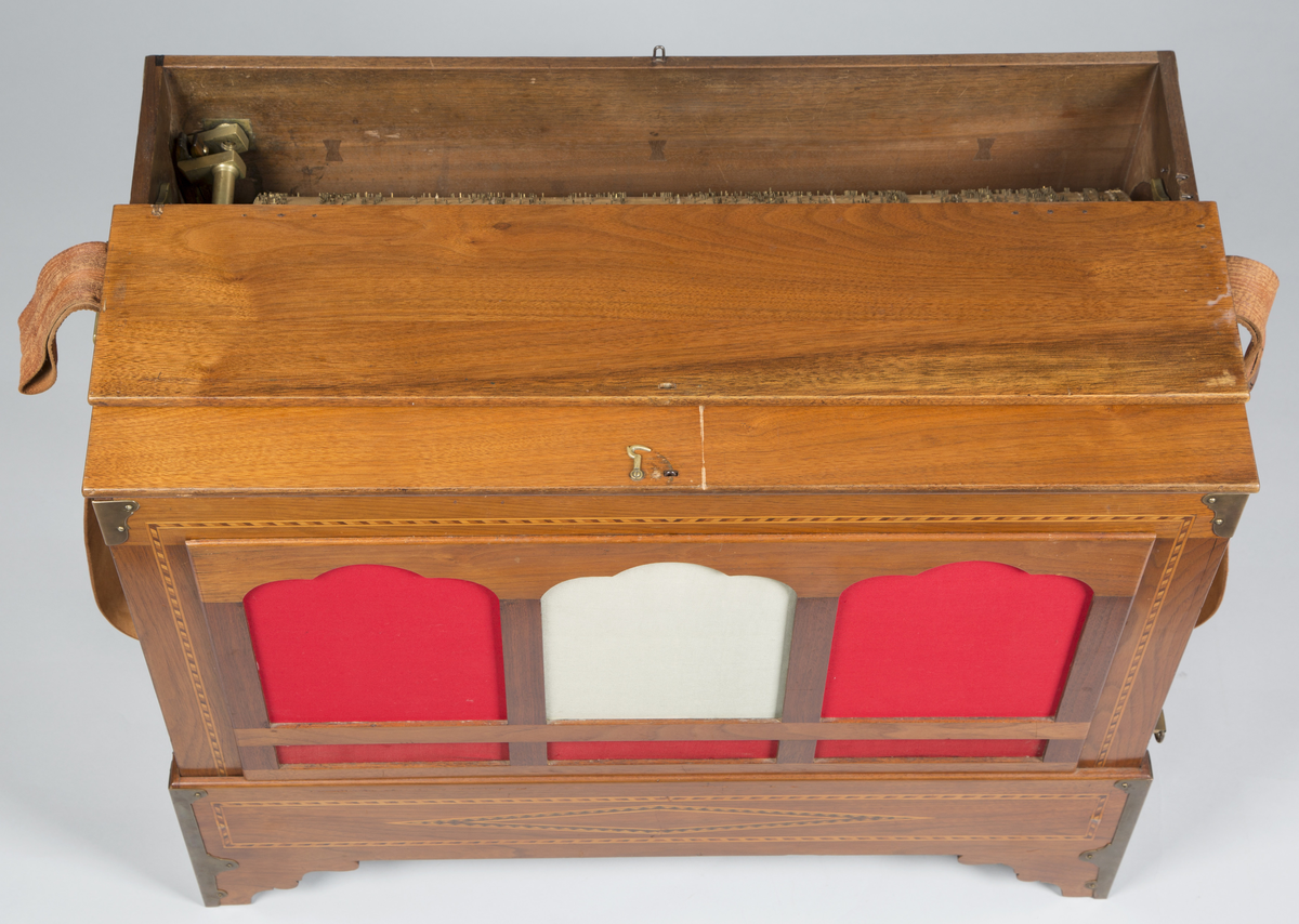 Lirekasse "Storspælle" med tilhørende rull (B). Instrumentet har 28 toner, fem register og todelt belg. Kassen er dekorert med intarsia.

Toner: C, D, F, G, A, H, c, d, e, f, f#, g, a, b, h, c’, d’, e’, f’, f#’, g’, a’, b’, h’, c’’, d’’, e’’, f’’
[men fremre reg står C, C#, D, E, F, G, .. uklar betydning]

Register:
8’ gedakt (plassert under bunn, unntatt C-pipen, som ligger over de andre stående pipene)
4’ 8 åpne piper i diskant, resten gedakt
2 2/3’ «kvint»; 13 åpne piper
2’ kun melodi (f# og oppover), totalt 17 åpne piper
1 3/5 «ters» NB! 2’ i bassregister (f og nedover)

Todelt belg. Spesiell dekor på utlassventilsstang.
Forslag laget av bjørk («uvanlig for å være Tharaldsen» brukte annet løvtre vanligvis» JMF)
«Pen intarsia på kasse, god for å vøre Tharaldsen»JMF
Pipene er relativt rike på overtoner, sanns et resultat av en relativt lav oppsnitt (JMF).