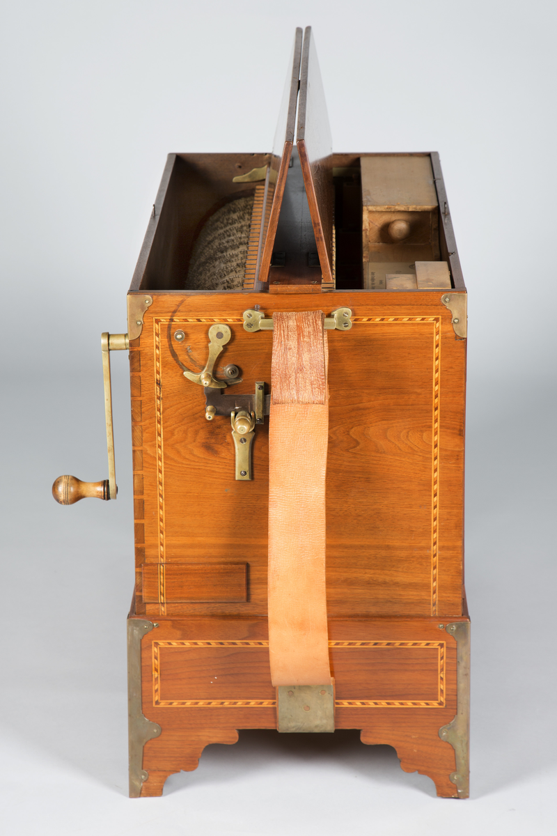 Lirekasse "Storspælle" med tilhørende rull (B). Instrumentet har 28 toner, fem register og todelt belg. Kassen er dekorert med intarsia.

Toner: C, D, F, G, A, H, c, d, e, f, f#, g, a, b, h, c’, d’, e’, f’, f#’, g’, a’, b’, h’, c’’, d’’, e’’, f’’
[men fremre reg står C, C#, D, E, F, G, .. uklar betydning]

Register:
8’ gedakt (plassert under bunn, unntatt C-pipen, som ligger over de andre stående pipene)
4’ 8 åpne piper i diskant, resten gedakt
2 2/3’ «kvint»; 13 åpne piper
2’ kun melodi (f# og oppover), totalt 17 åpne piper
1 3/5 «ters» NB! 2’ i bassregister (f og nedover)

Todelt belg. Spesiell dekor på utlassventilsstang.
Forslag laget av bjørk («uvanlig for å være Tharaldsen» brukte annet løvtre vanligvis» JMF)
«Pen intarsia på kasse, god for å vøre Tharaldsen»JMF
Pipene er relativt rike på overtoner, sanns et resultat av en relativt lav oppsnitt (JMF).