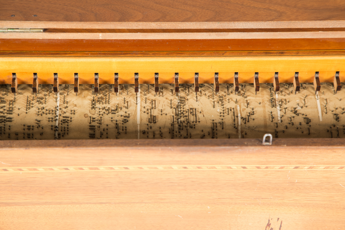 Lirekasse "Storspælle" med tilhørende rull (B). Instrumentet har 28 toner, fem register og todelt belg. Kassen er dekorert med intarsia.

Toner: C, D, F, G, A, H, c, d, e, f, f#, g, a, b, h, c’, d’, e’, f’, f#’, g’, a’, b’, h’, c’’, d’’, e’’, f’’
[men fremre reg står C, C#, D, E, F, G, .. uklar betydning]

Register:
8’ gedakt (plassert under bunn, unntatt C-pipen, som ligger over de andre stående pipene)
4’ 8 åpne piper i diskant, resten gedakt
2 2/3’ «kvint»; 13 åpne piper
2’ kun melodi (f# og oppover), totalt 17 åpne piper
1 3/5 «ters» NB! 2’ i bassregister (f og nedover)

Todelt belg. Spesiell dekor på utlassventilsstang.
Forslag laget av bjørk («uvanlig for å være Tharaldsen» brukte annet løvtre vanligvis» JMF)
«Pen intarsia på kasse, god for å vøre Tharaldsen»JMF
Pipene er relativt rike på overtoner, sanns et resultat av en relativt lav oppsnitt (JMF).