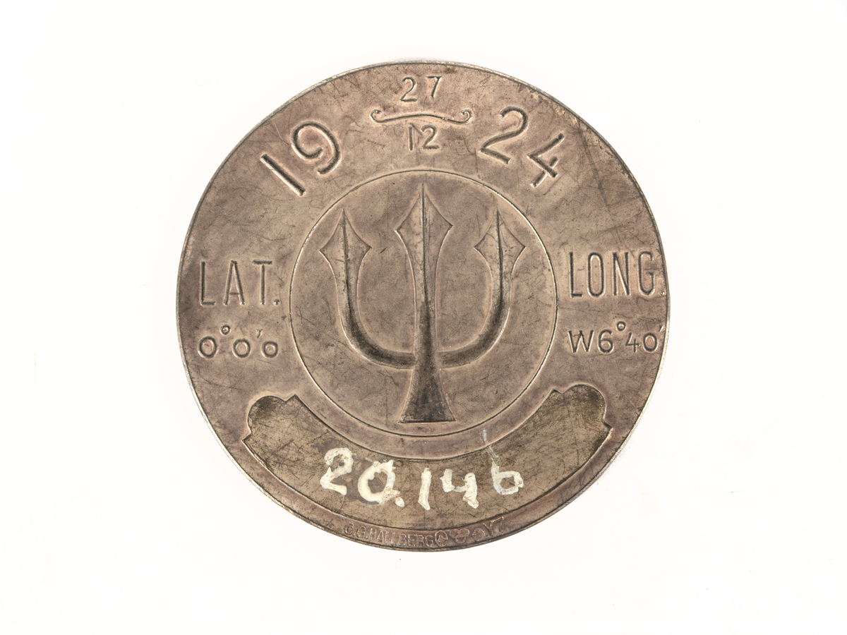 Åtsida: Bild av jordglob med platsmarkering på ekvatorn. Omgiven av 2 treuddar samt text: H.M. FYLGIA 1924 Linjen.
Frånsida: Bild av treudd och text: 19-27/12-24, lat. 0Â° o'o. W 6Â° 40'. Plats för gravering under.