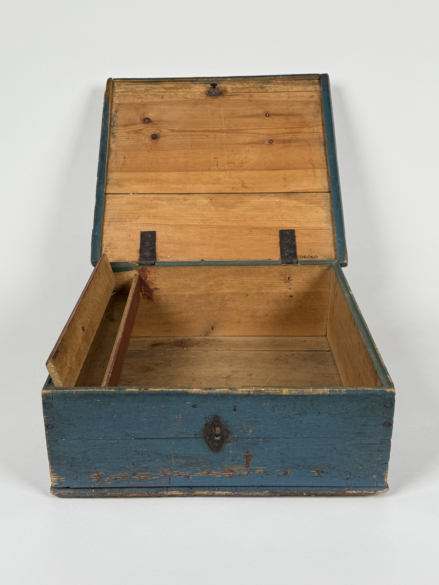 Skrin av furu med sinkade hörn och underifrån itappad botten. Gångjärn, låshake och nyckelskylt. Lås saknas (har varit utanpåliggande). Läddika med lock. Målat utvändigt med stiliserad blomsterdekor i gult, rött och svart mot heltäckande blå botten. 