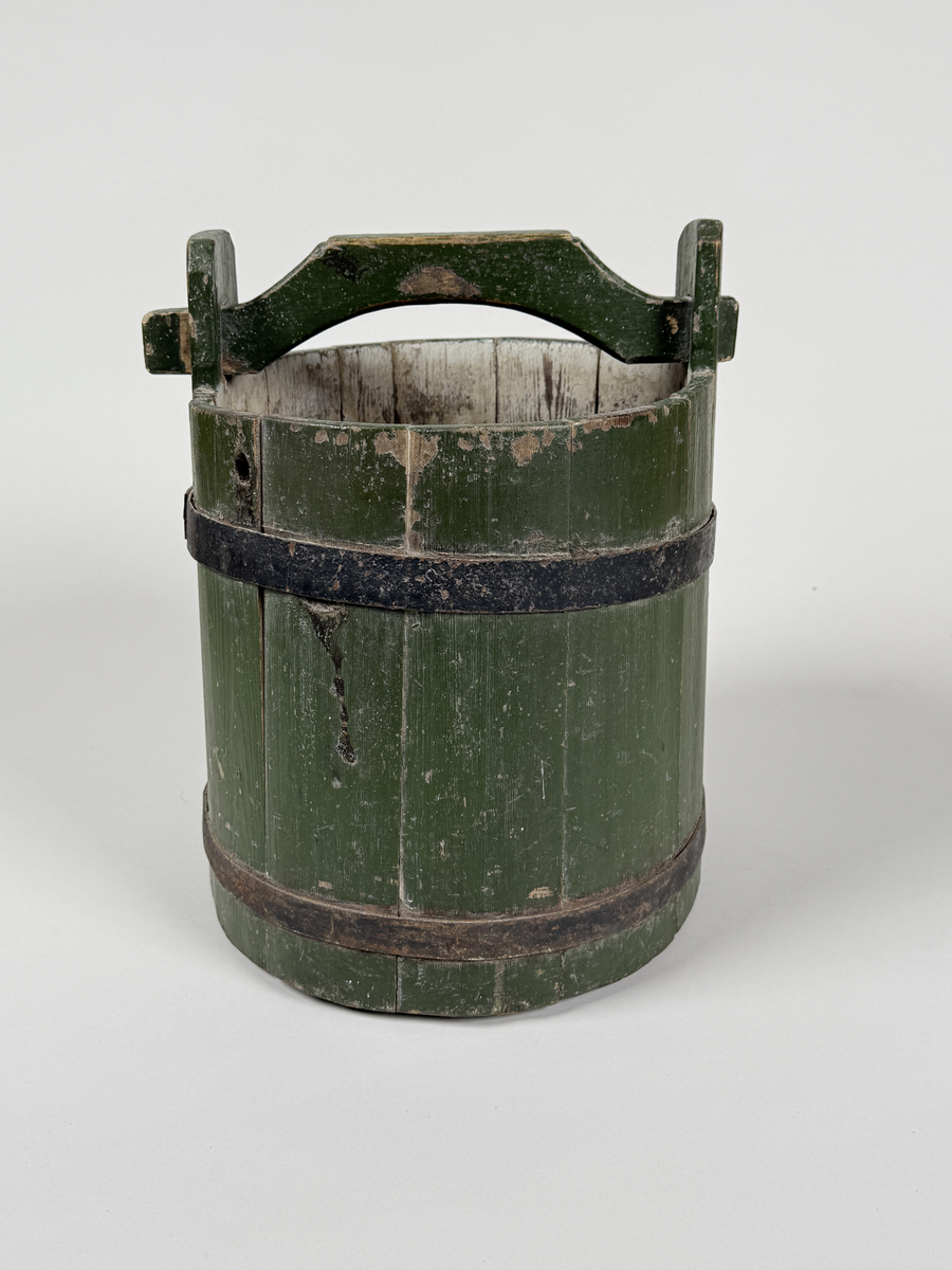 Vattenspann. Av furu, grönmålat laggkärl med handtag, två svarta järnband runt. 