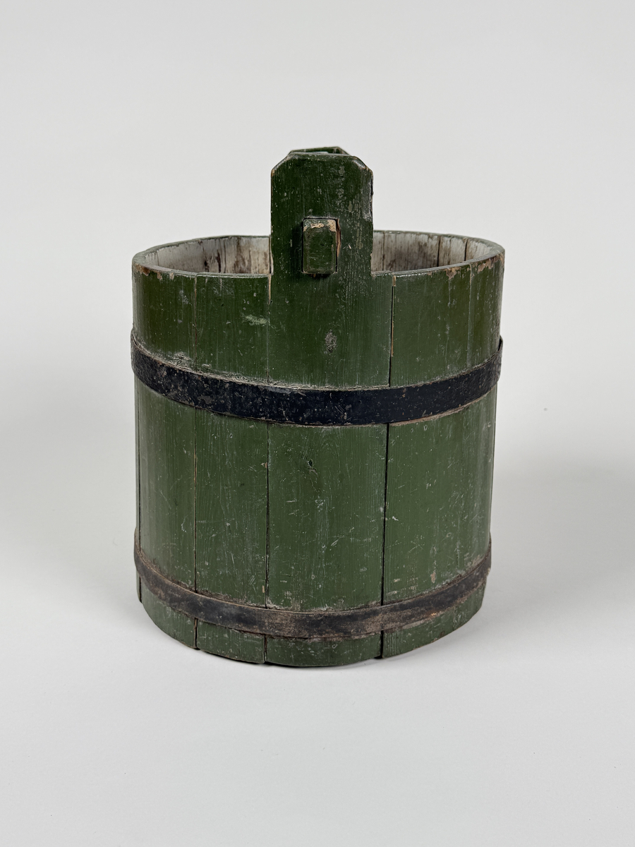 Vattenspann. Av furu, grönmålat laggkärl med handtag, två svarta järnband runt. 