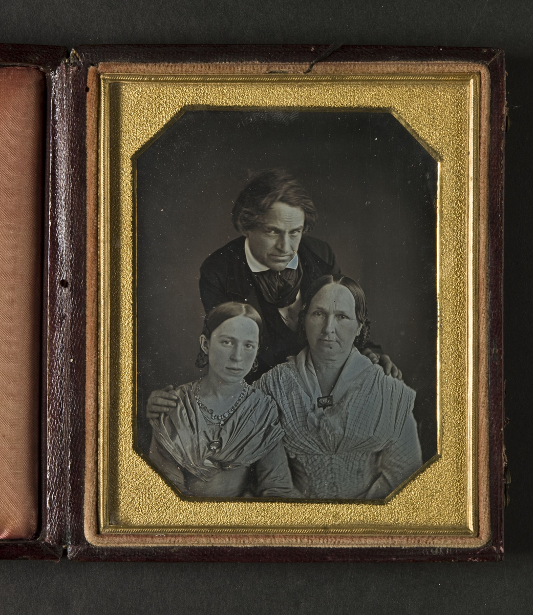 Familjeporträtt av man, hustru och dotter.