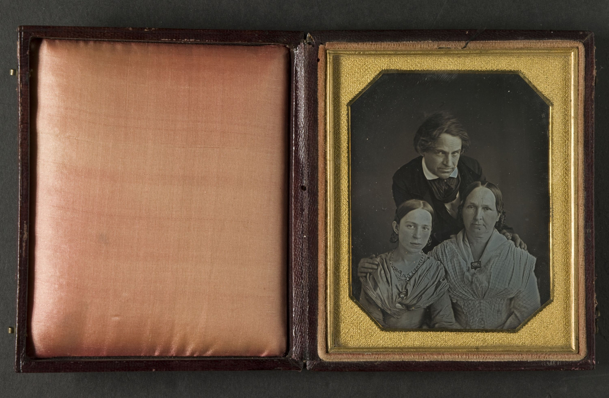 Familjeporträtt av man, hustru och dotter.