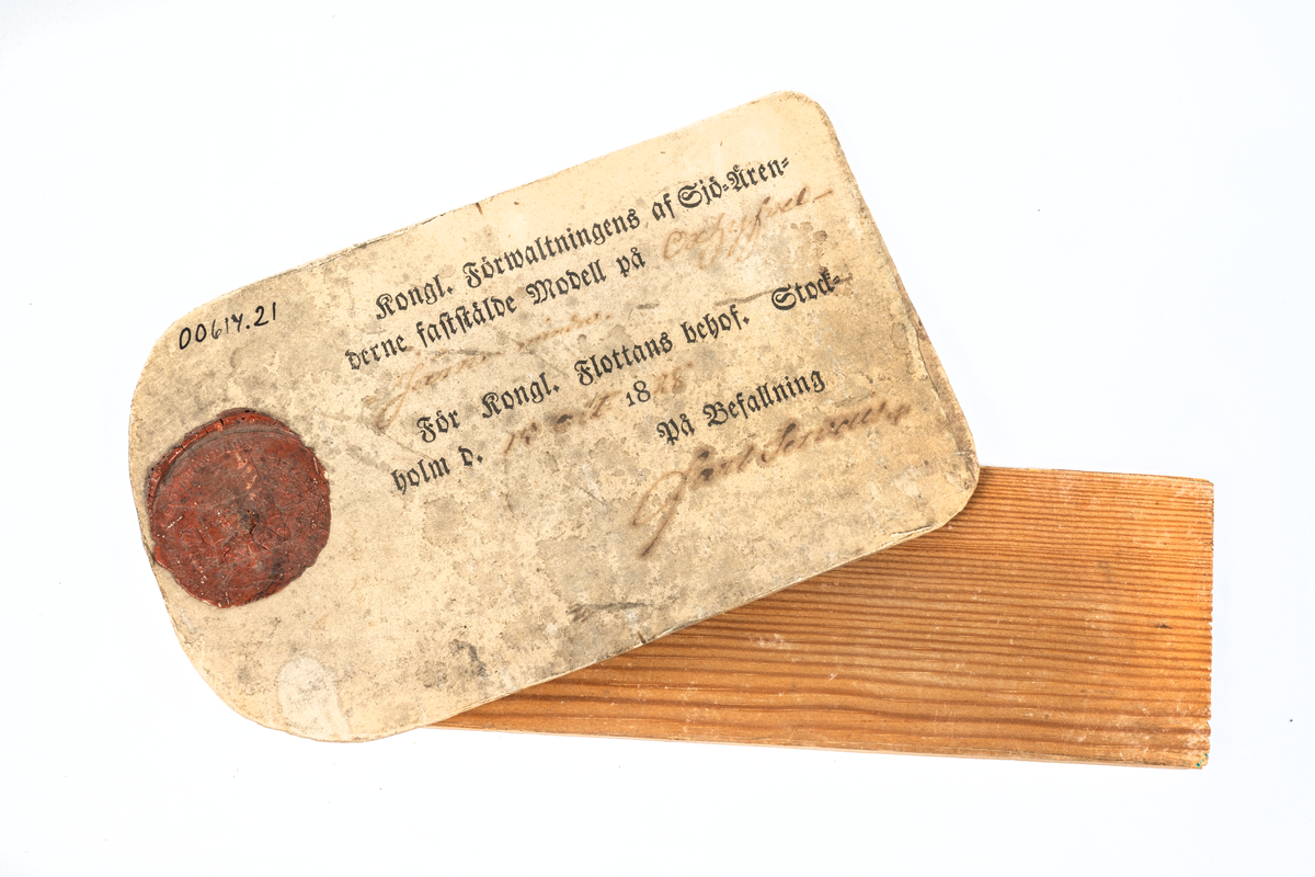 Modell i trä av oxhyveljärn. Vidhäftad etikett med sigill och texten "Kongl. Förwaltningens af Sjö-ärenderne faststälde modell på oxhyfveljärn mindre. För Kongl. Flottans behof. Stockholm d. 19 oct. 1828. På befallning Carl Servais". Påskrift på föremålet: Ox hyfvel järn n:o 1"