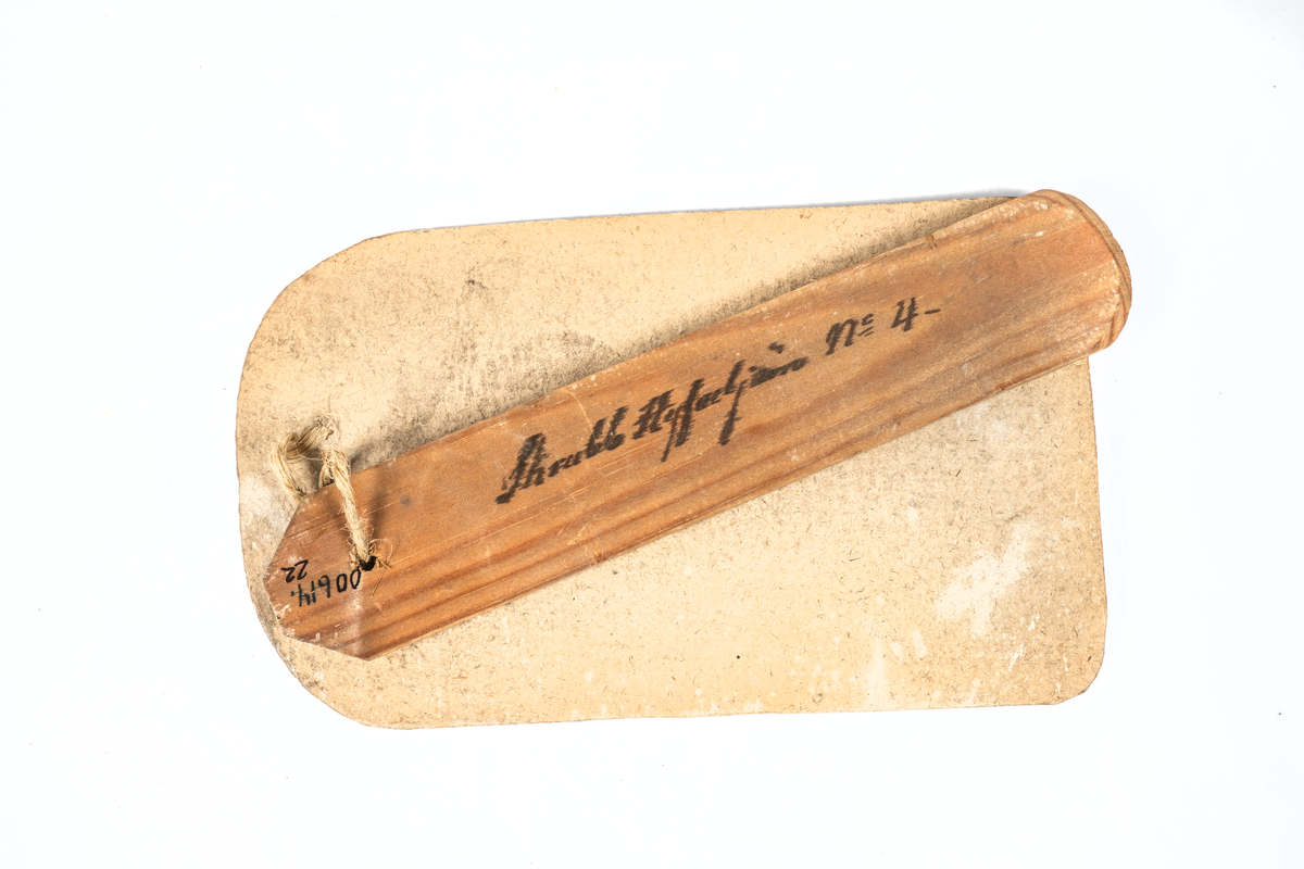 Modell i trä av skrubbhyveljärn. Vidhäftad etikett med sigill och texten "Kongl. Förwaltningens af Sjö-ärenderne faststälde modell på Skrubb-Hyfvel-järn. För Kongl. Flottans behof. Stockholm d. 19 oct. 1828. På befallning Carl Servais". Påskrift på föremålet: "Skrubb Hyfveljärn n:o 4"