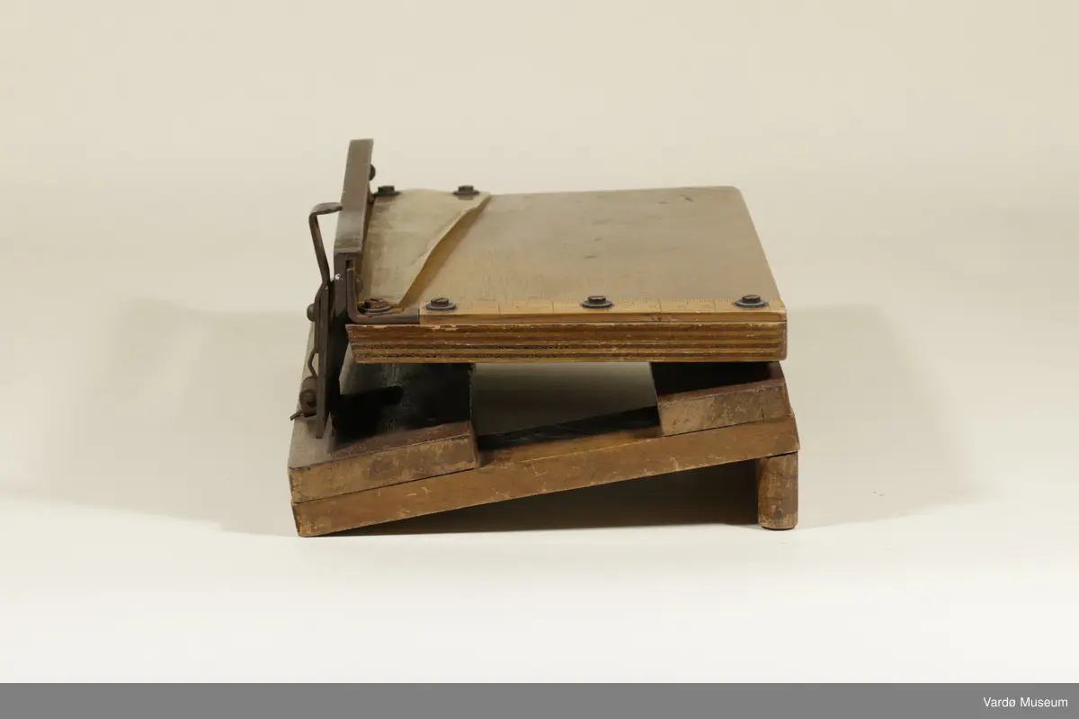 Papir guillotin laget av tre, plast og metall.