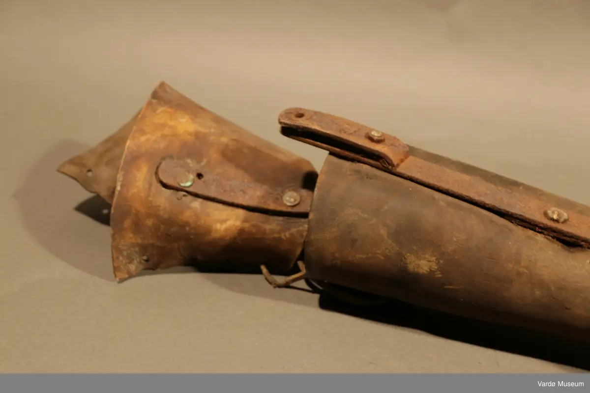 Benprotese . Gjenstand er kledd i rødbrunt lær på legg, fot og lår. Protesen har fire hull på øverste del til både stramme og løsne av et snørebånd.