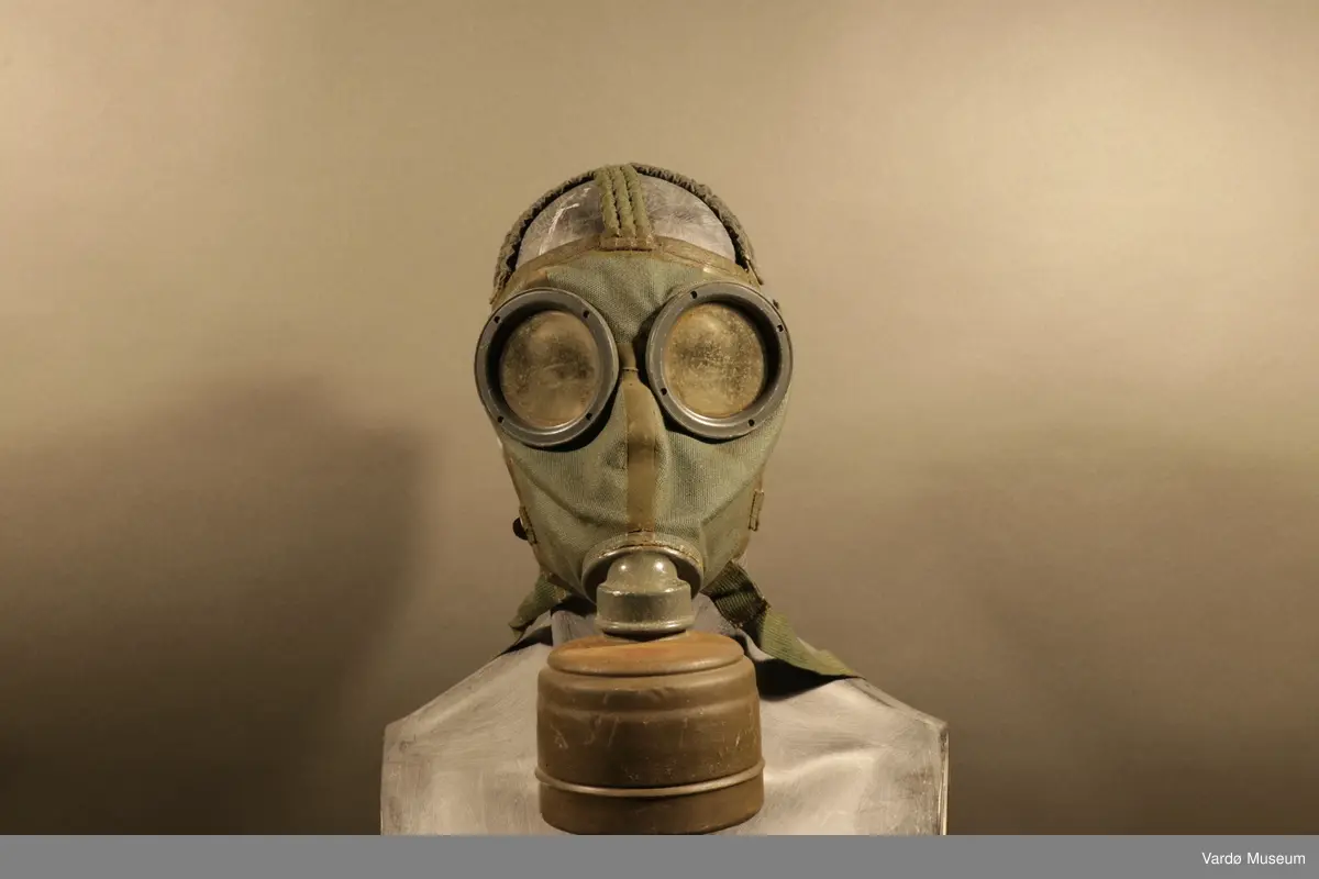 Tyske gassmaske komplett med gass- og støvfilter. Masken er en ansiktsmaske med synsfelt som sirkelrunde glassflater. Masken har fem festereimer og et tekstil samle-punkt . I tillegg til festereimer har gassmasken både en tverrstropp og en nakkestropp. Gassmaske har et rundt festepunkt til gass og støvfilteret.